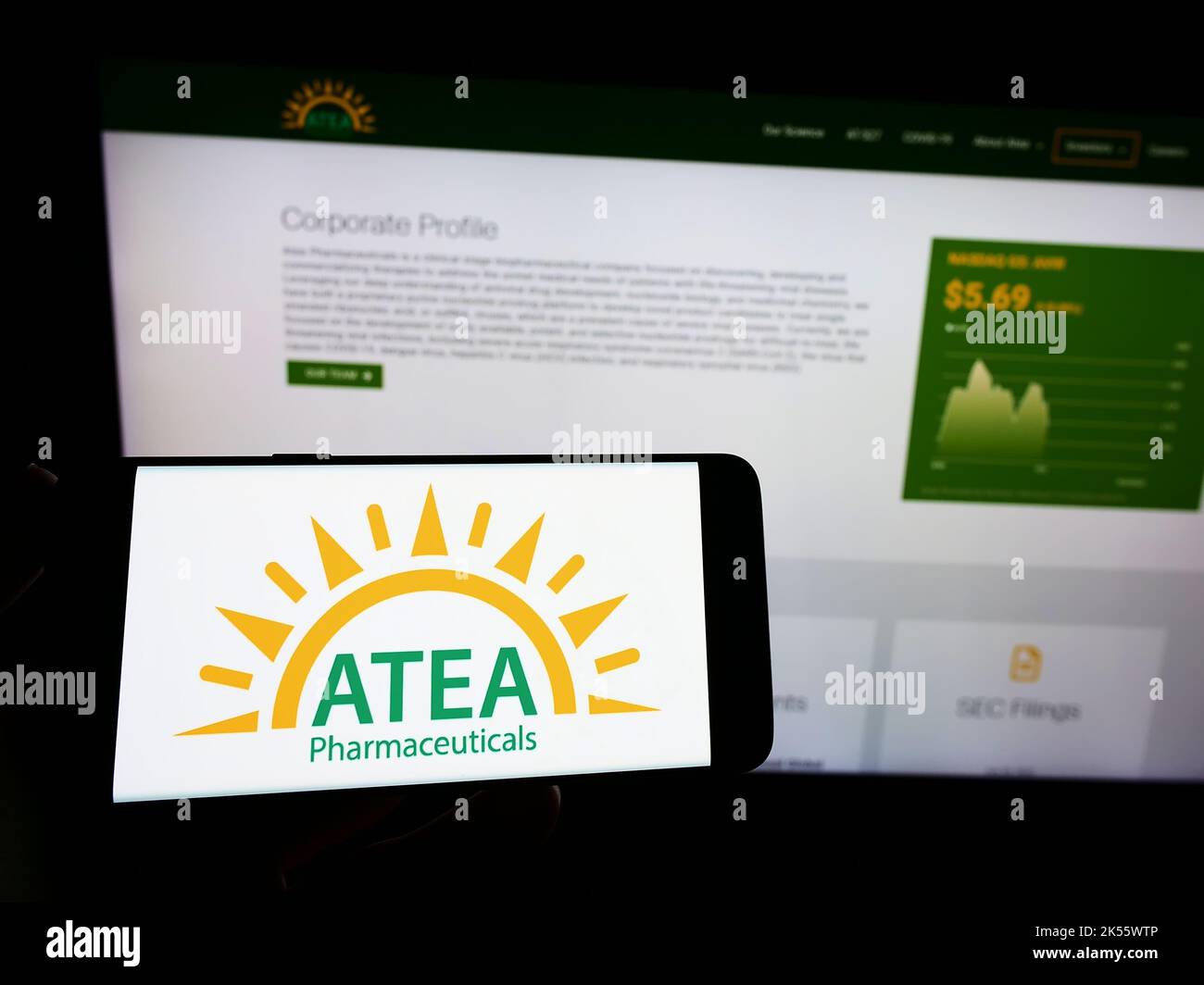 Person holding smartphone with logo of US company Atea Pharmaceuticals Inc. on screen in front of website. Focus on phone display. Stock Photo