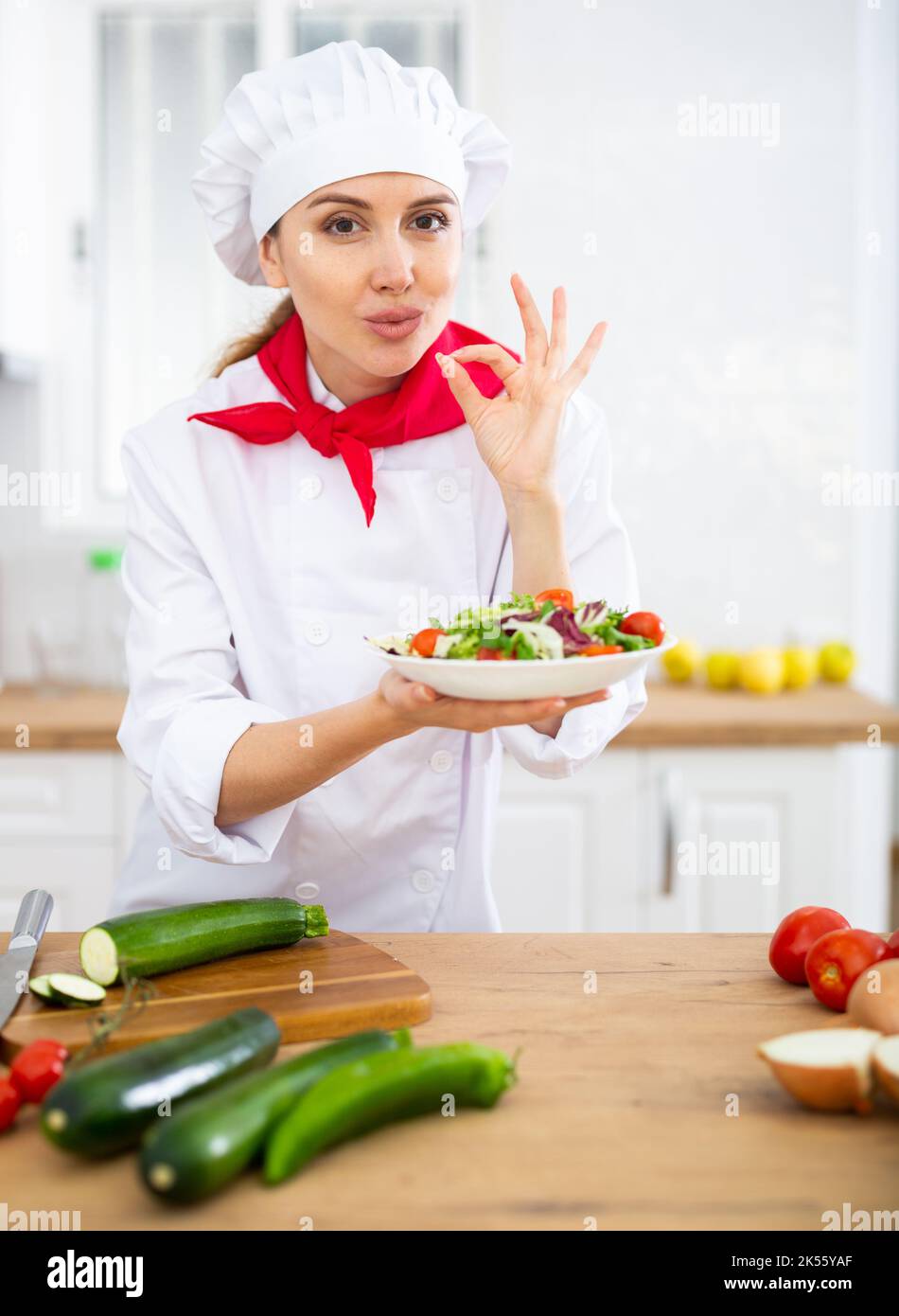 Female chef demonstrating excellent salad in the kitchen Stock Photo ...