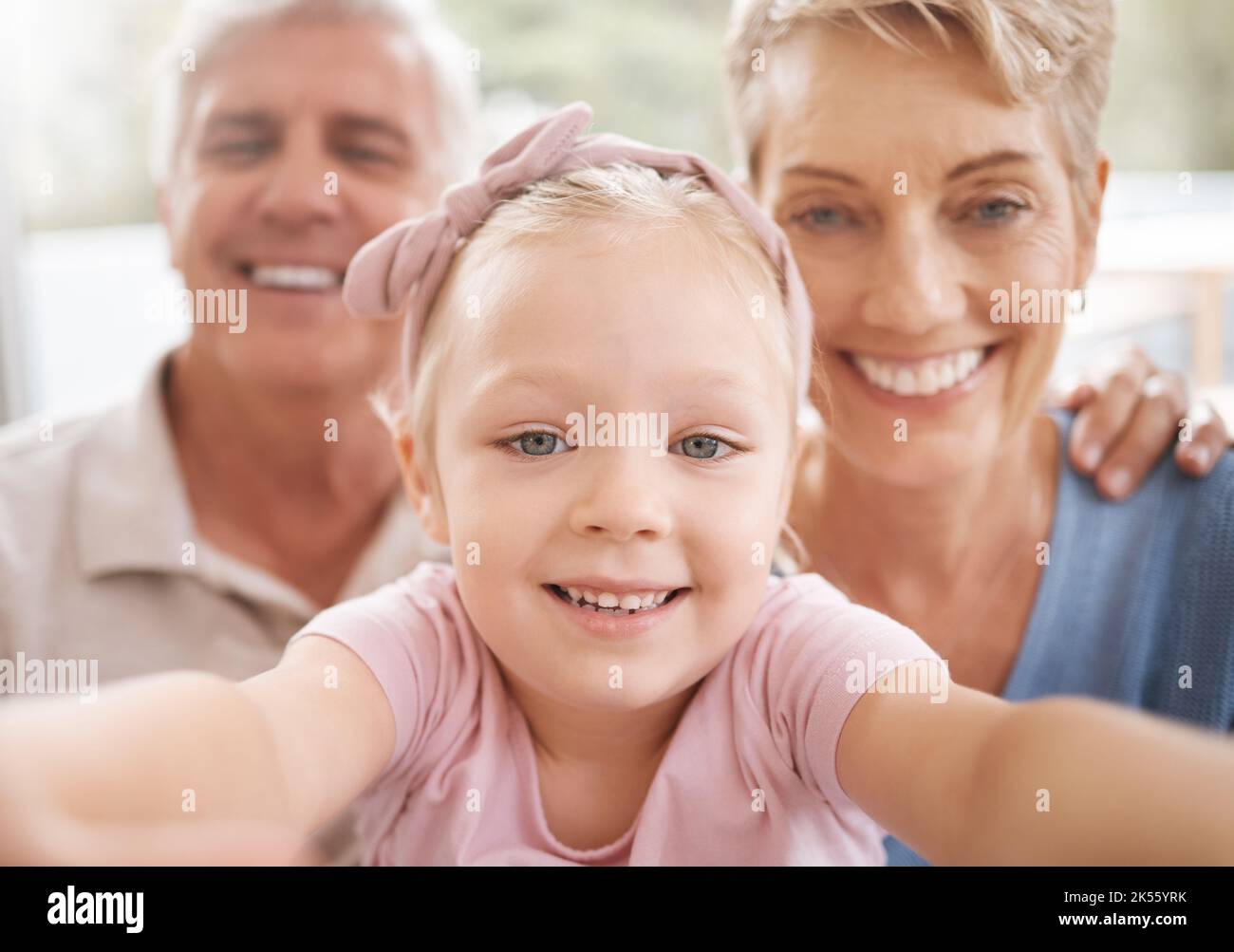Girl, grandparents and family selfie portrait in home having fun spending quality time together. Love, support and grandma, grandpa and kid taking a Stock Photo