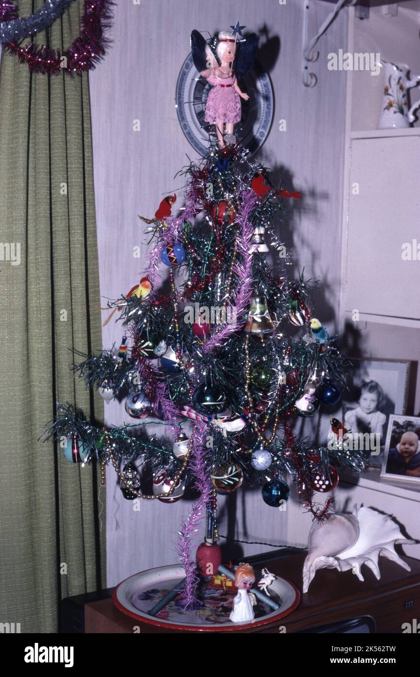 An 1970s Artificial Christmas Tree with decorations in a Family Living Room on top of a TV Set, London, United Kingdom Stock Photo