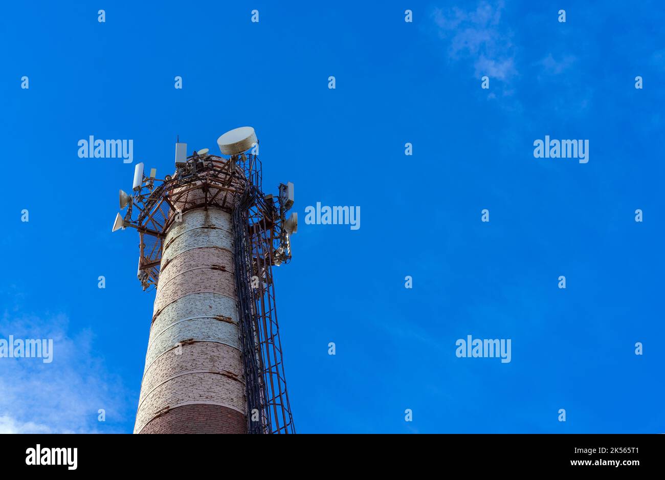 Telecommunications tower with cellular network antennas against the blue sky. Stock Photo