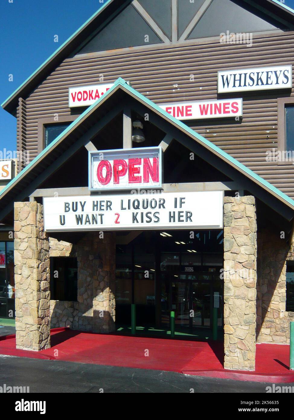 Sign above the door of an American liquor store 'buy her liquor if u want to kiss her' Stock Photo