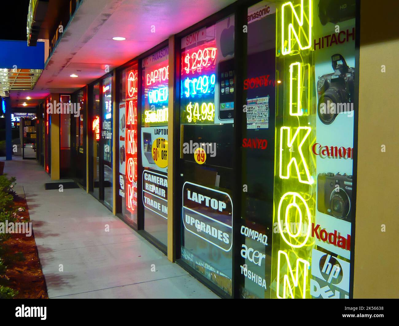 Outside a camera shop with neon signs for Canon and Nikon Stock Photo