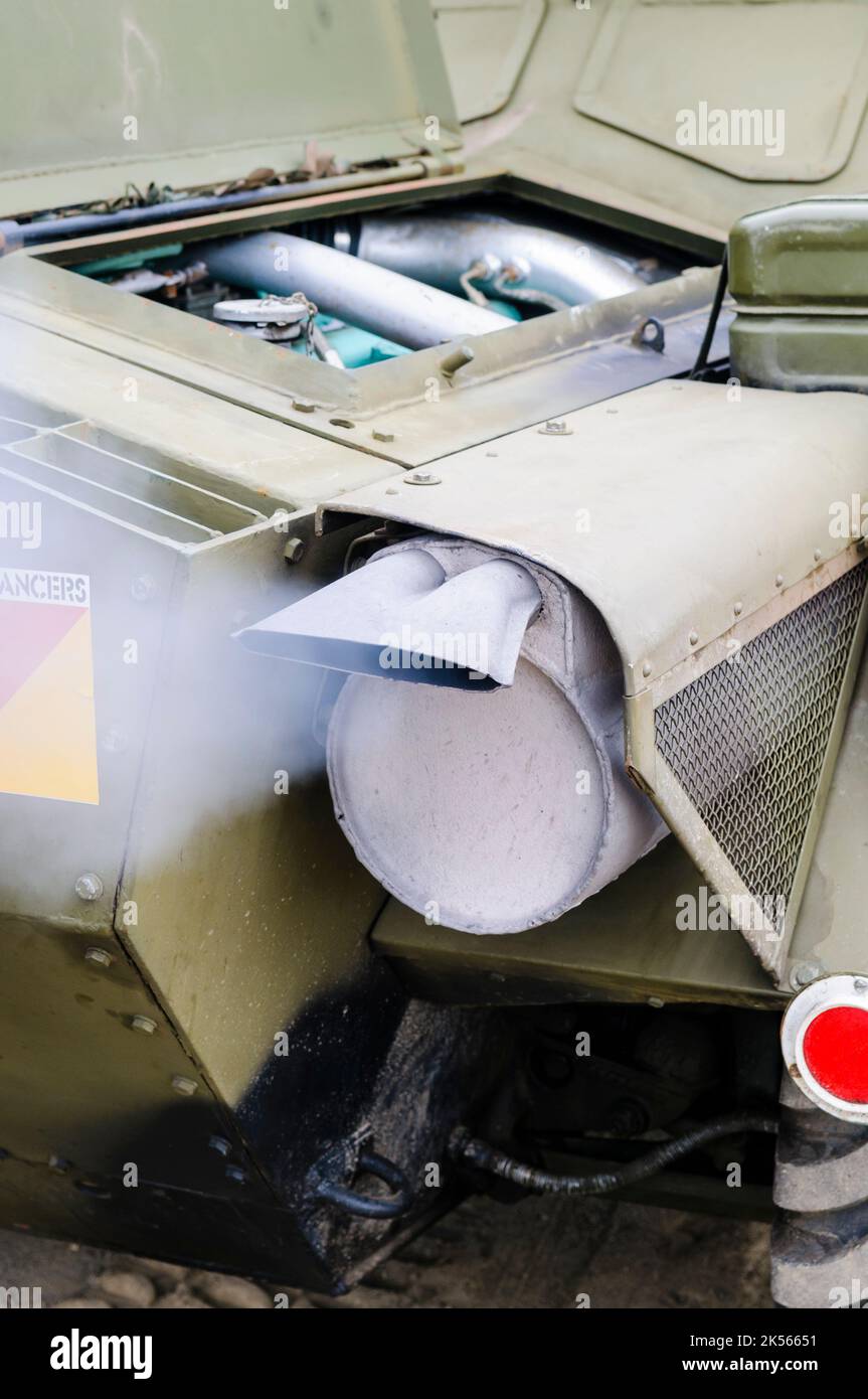 Smoke billows from the exhaust of a diesel engine on an old British Army tank. Stock Photo