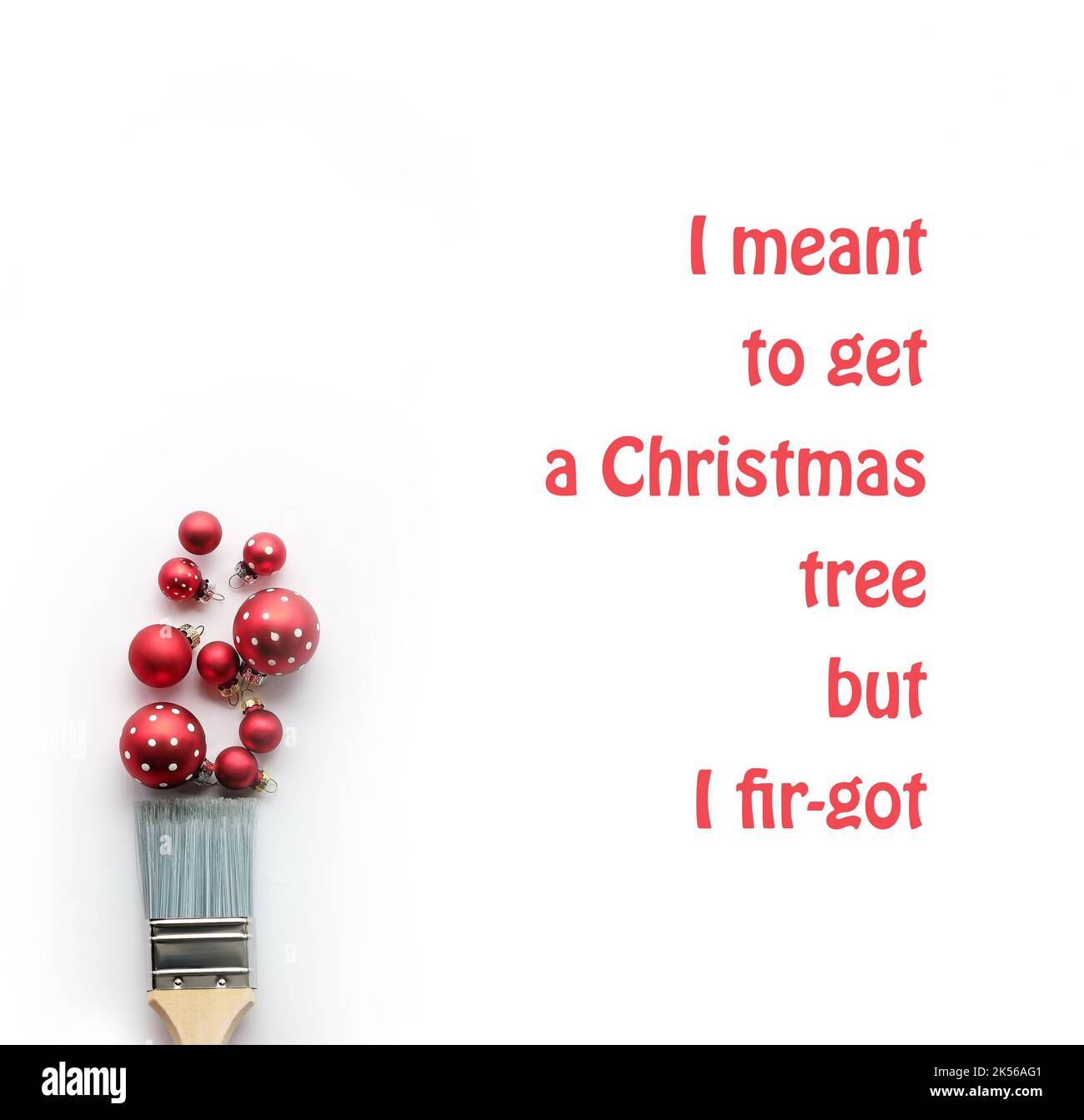 Painting brush in hand, red paint from Christmas baubles, balls, Xmas trinkets. Creative simple