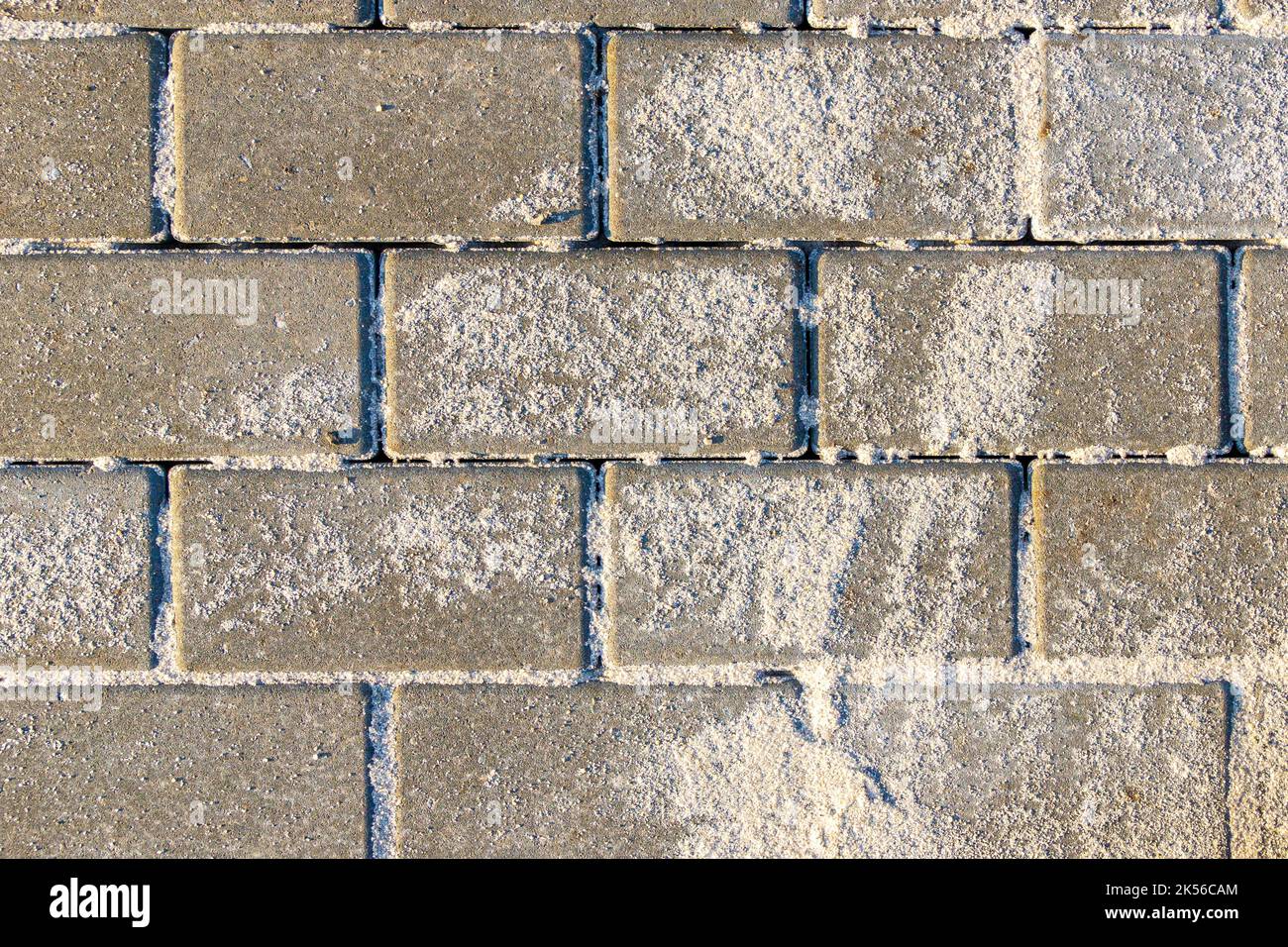 sanding a new paving slab to fill joints or to ensure safe walking on