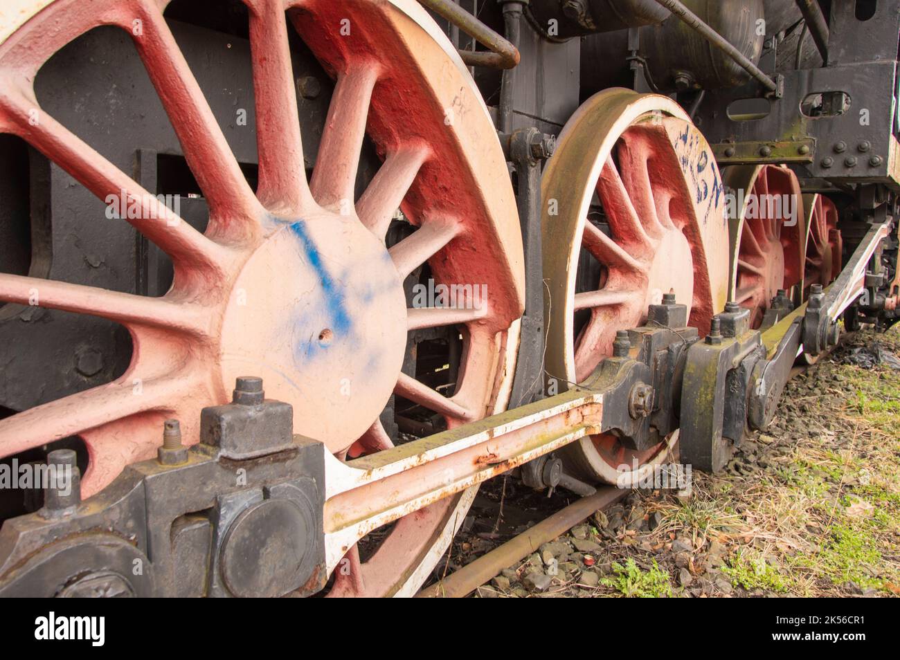 Drive transmission mechanism in a historic and damaged steam locomotive standing on a sidetrack. Stock Photo
