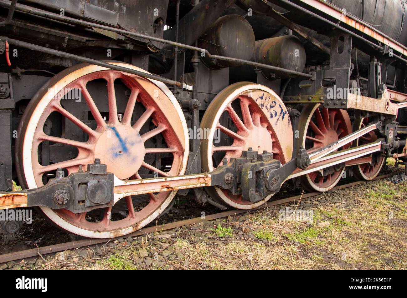Drive transmission mechanism in a historic and damaged steam locomotive standing on a sidetrack. Stock Photo