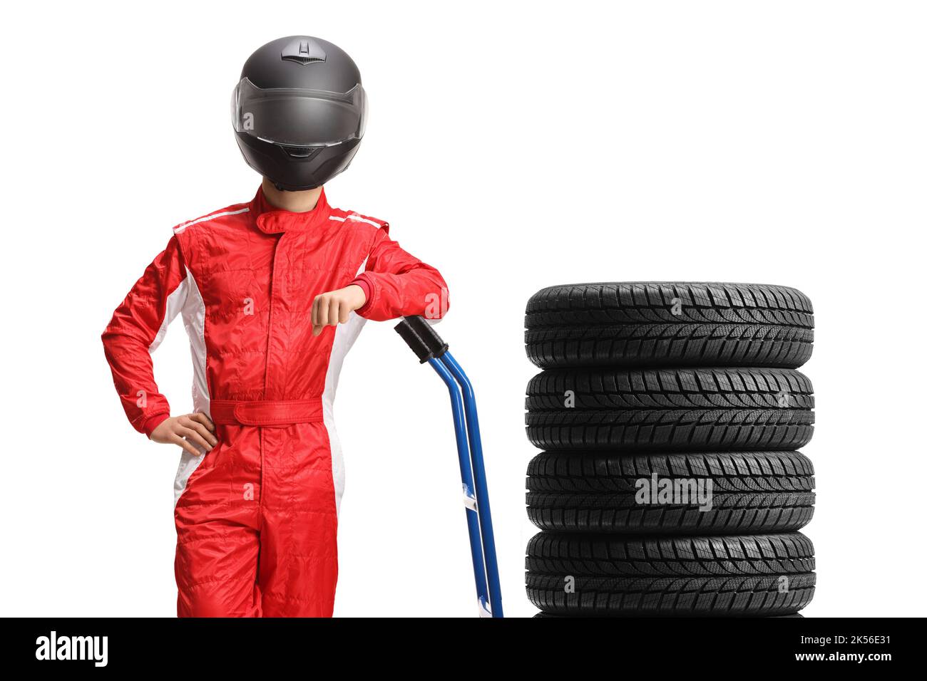 Car racer with a helmet and suit leaning on a hand truck with tires isolated on white background Stock Photo
