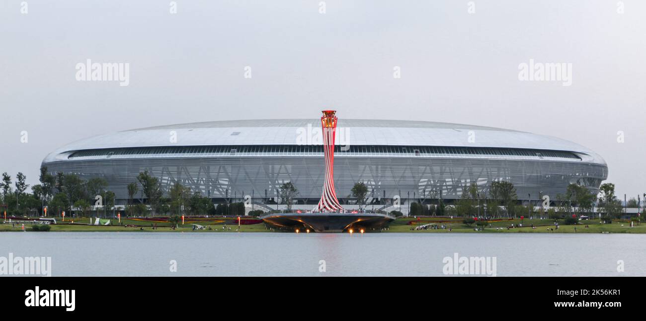 Chengdu, China - 4th October 2022: Panoramic shot of the torch tower lit up in red in front of the vast Dong’an Stadium, one of the main venues of the Stock Photo