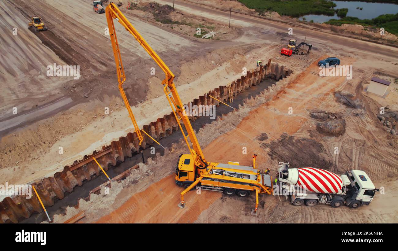 Lorry crane, truck concrete mixer and other machinery working on a road construction site in Warsaw, Poland. Drone top view. High quality photo Stock Photo