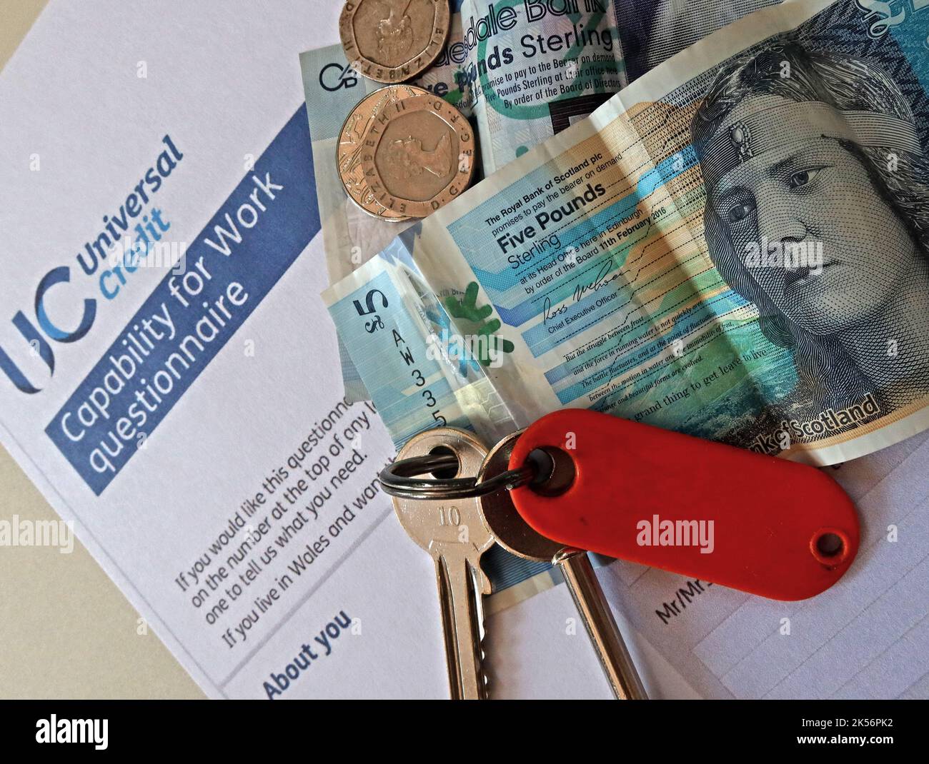 UC Universal credit - capability For Work Questionnaire, with cash, pound notes, house keys Stock Photo