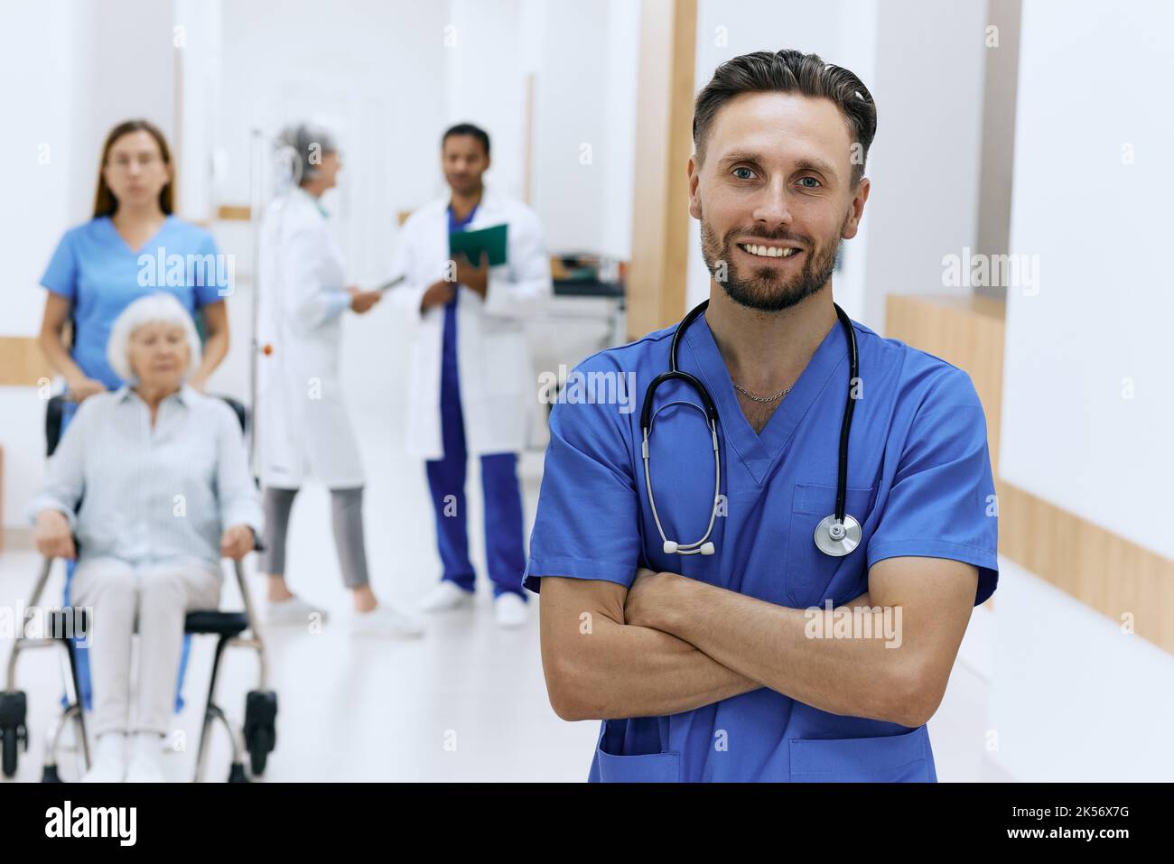 Handsome male physician with stethoscope standing in front view of