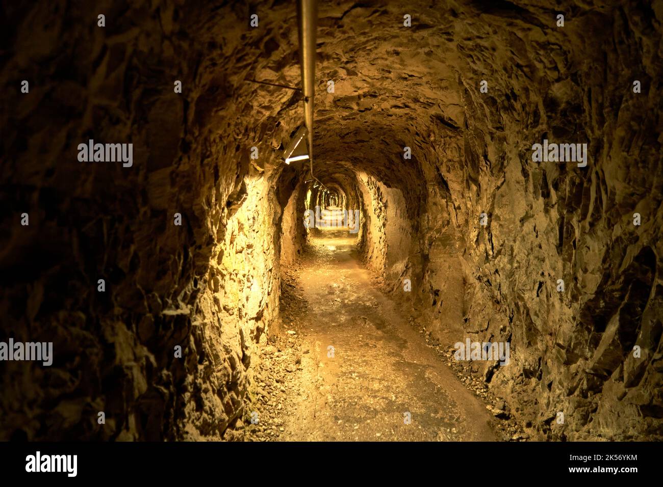 Narrow tunnel with raw rock walls underground Stock Photo