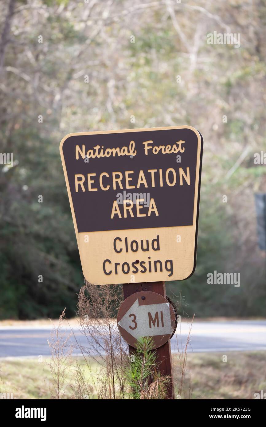 OUT OF FOCUS KISATCHIE NATIONAL FOREST CLOUD CROSSING RECREATION AREA SIGN WITH ARROW POINTING LEFT AND A NOTE THAT THE AREA IS 3 MILES AWAY, KISATCHI Stock Photo