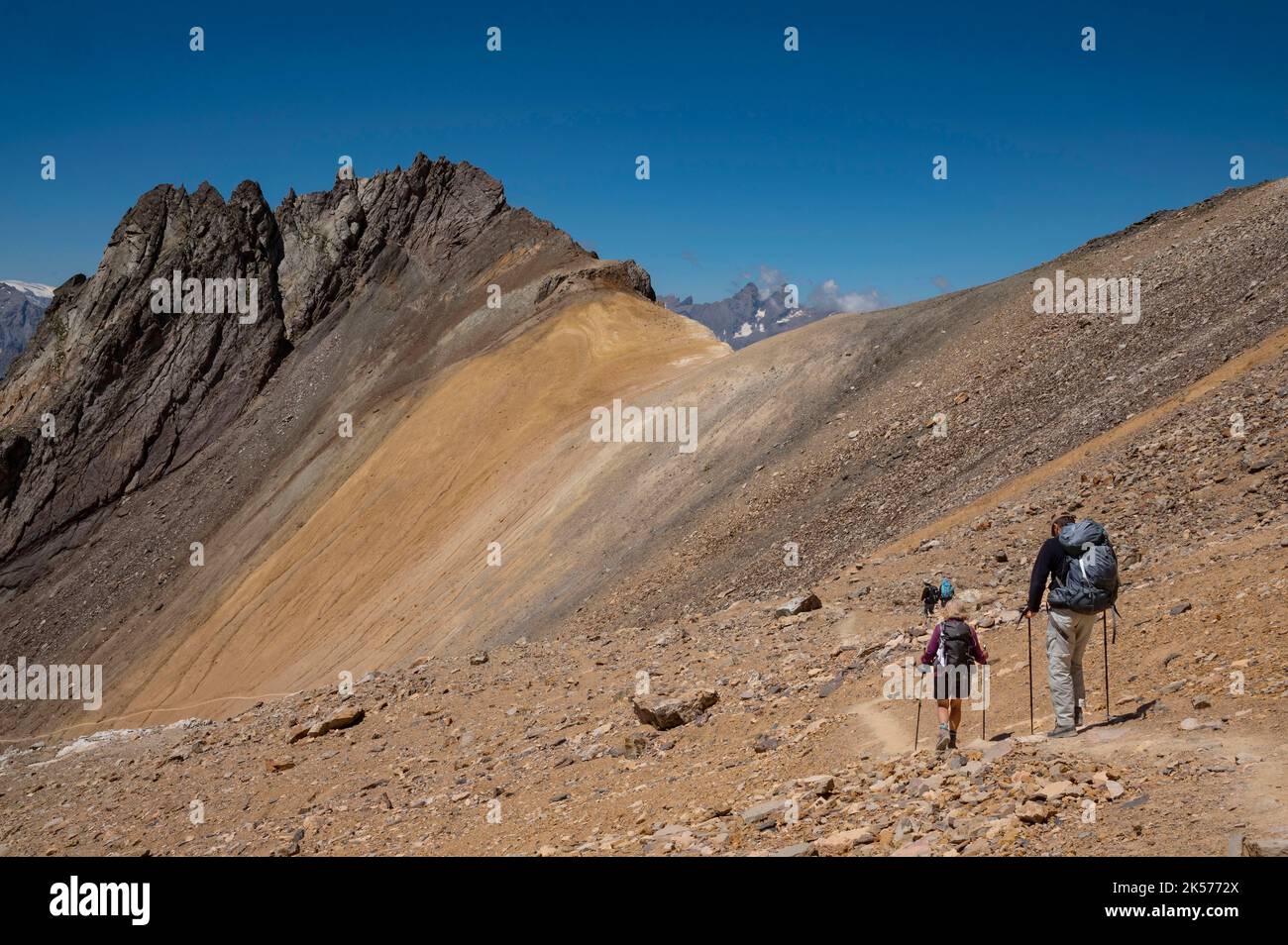 France, Savoie, Valmeinier, Thabor massif, trek around the Thabor; below the summit, group of hikers in the desert crossing towards the Col de la Chapelle, the Pointe des Angelières and the Aiguilles d'Arve Stock Photo