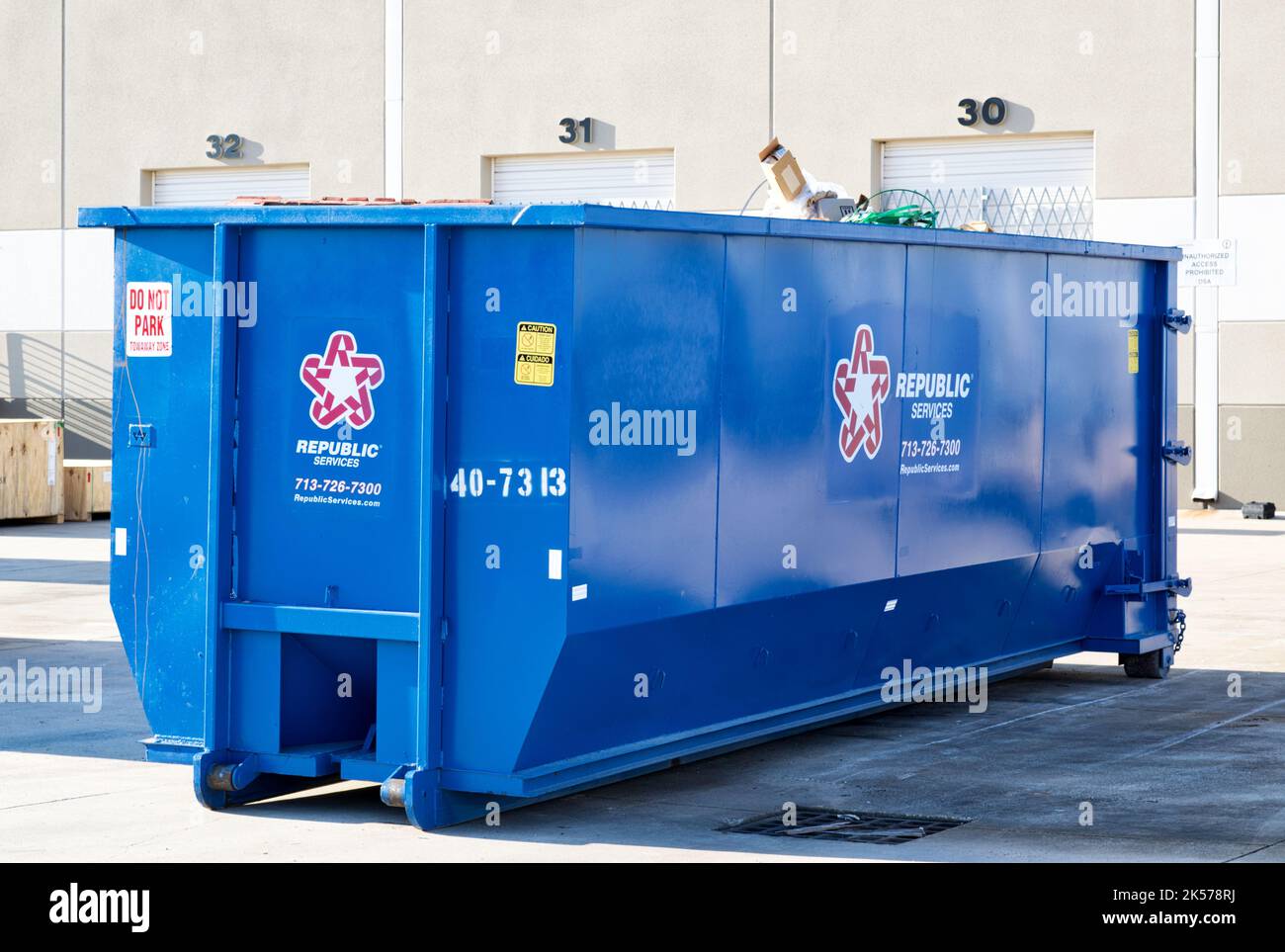Houston, Texas USA 09-18-2022: Republic Services waste management solid trash dumpster bin in a warehouse yard. Stock Photo