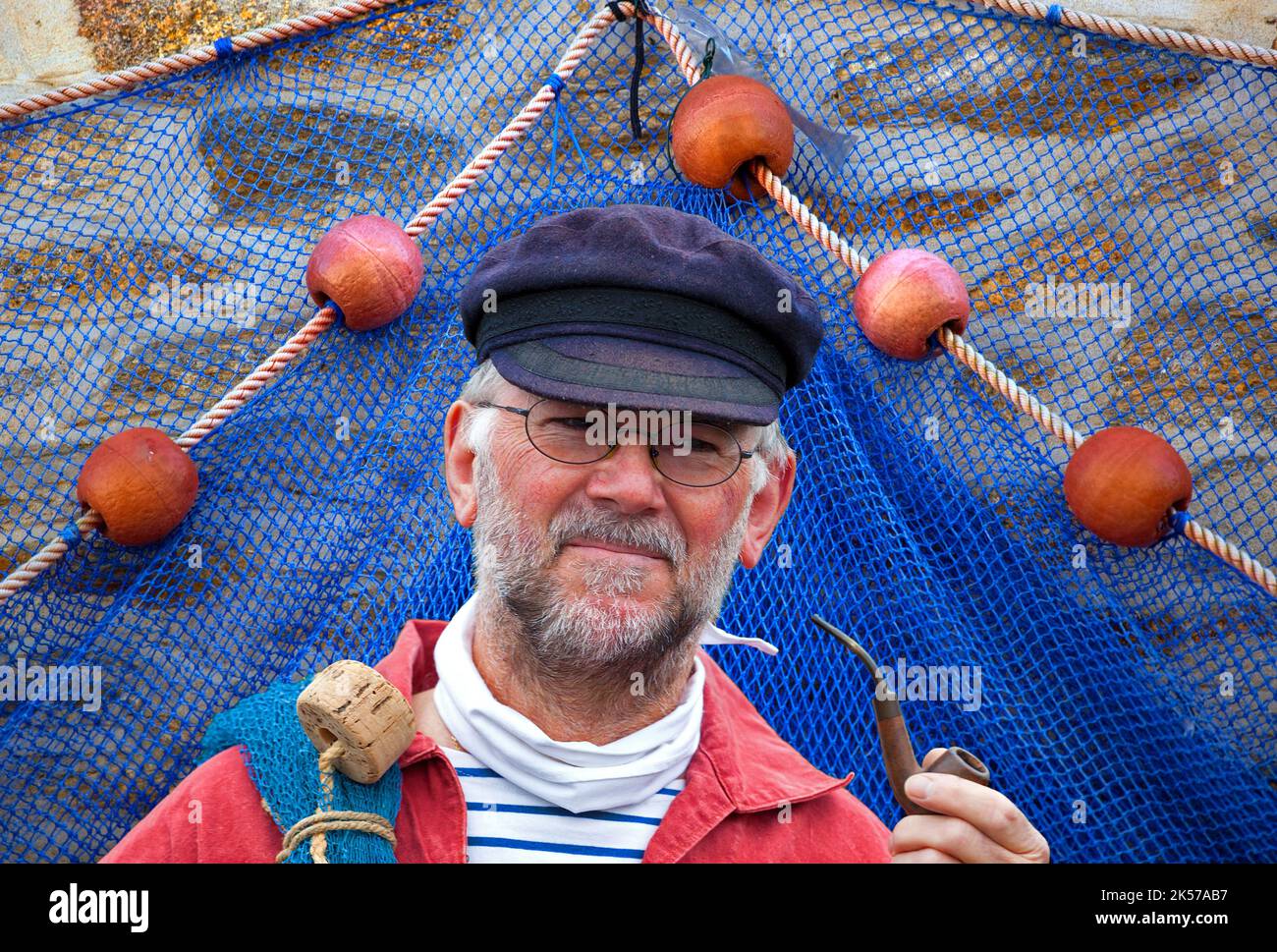 France, Finistère (29), Concarneau, marin et sa pipe devant un filet de pêche lors du Festival des Filets Bleus Stock Photo