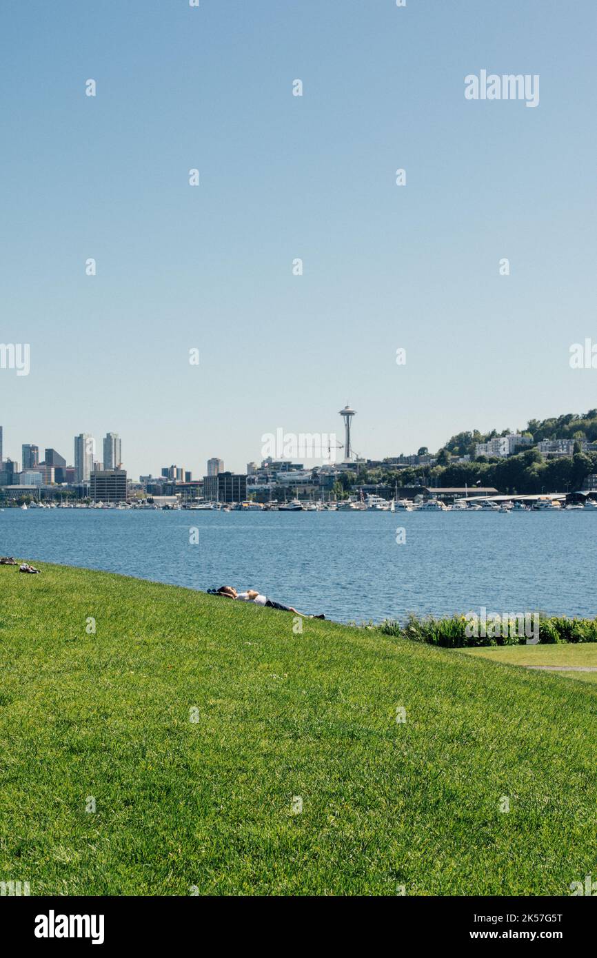 person napping on grassy hill of Gasworks park facing Space Needle in