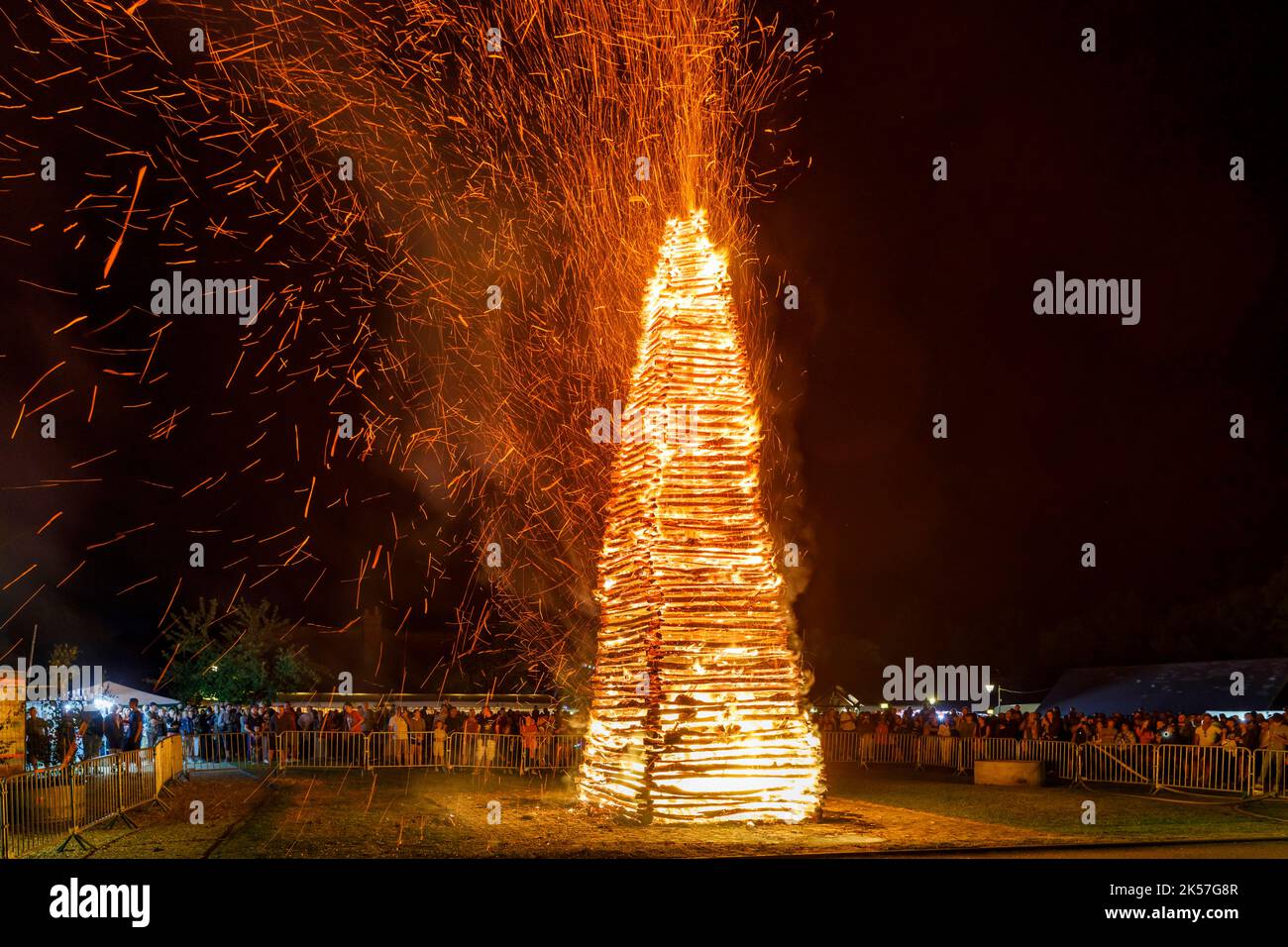 France, Eure, La Haye-de-Routot, traditional bonfire of Saint-Clair, a 15 meters high pyramid of dry wood is erected, on the village square, in front of the church and its thousand-year-old yews. A mass and a blessing precede the burning of the stake, if the cross at the top does not burn, it is a good sign for the 12 months to come, bringing back home a piece of charred wood, called brandon, will protect the house against lightning Stock Photo