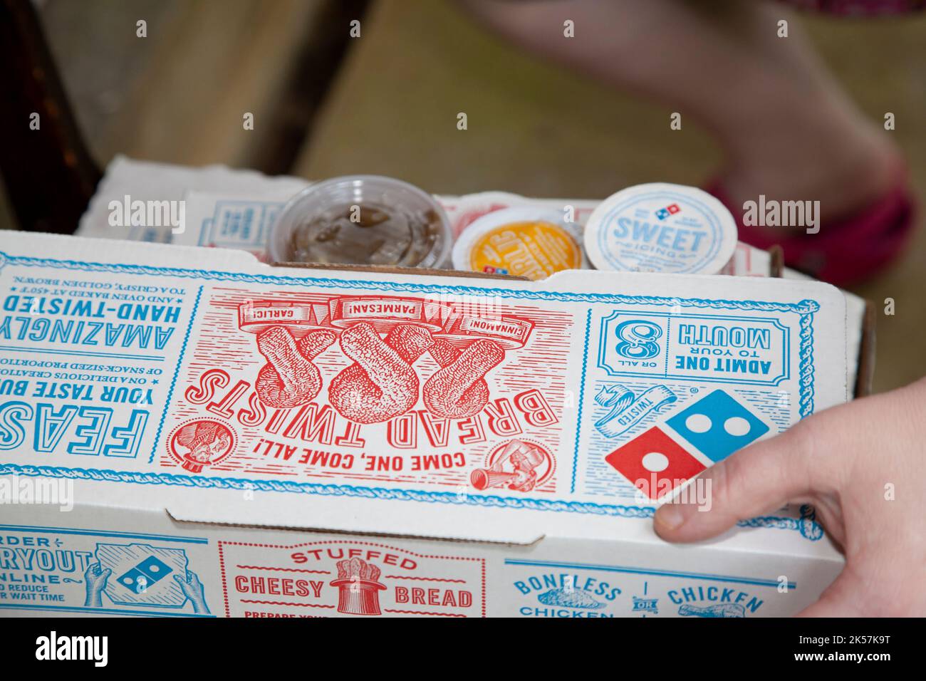 DOMINOES DELIVERY BOXES, RUSTON, LOUISIANA/USA MAY 15, 2020 Person grabbing Dominos pizza and