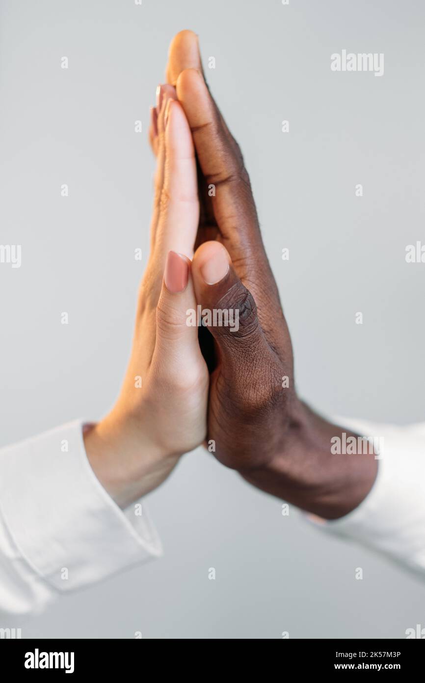 Gender equality. Interracial unity. Multiethnic solidarity. Tolerance acceptance. Closeup of diverse male female business people high five gesture iso Stock Photo