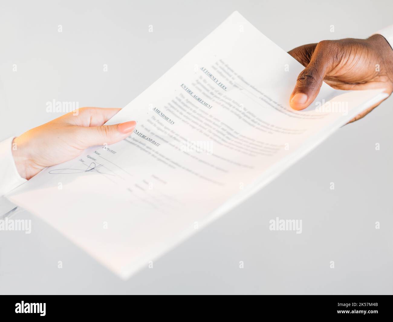 International contract. Global partnership. Multinational agreement. Closeup of diverse business people hands holding agreement paper isolated on neut Stock Photo