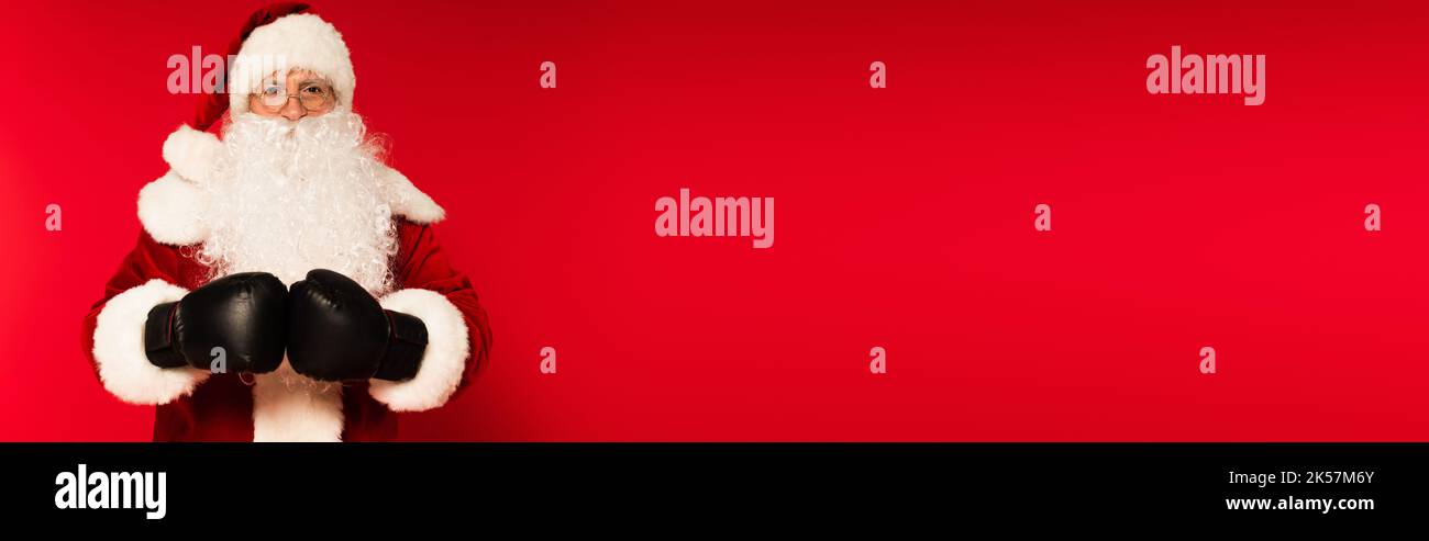 Father christmas in costume and boxing gloves on red background with copy space, banner,stock image Stock Photo