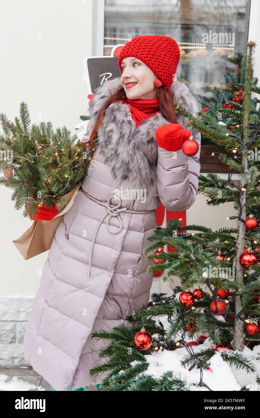 A bright woman in winter clothes walks around the city decorated for Christmas. Lifestyle in the winter season Stock Photo Alamy