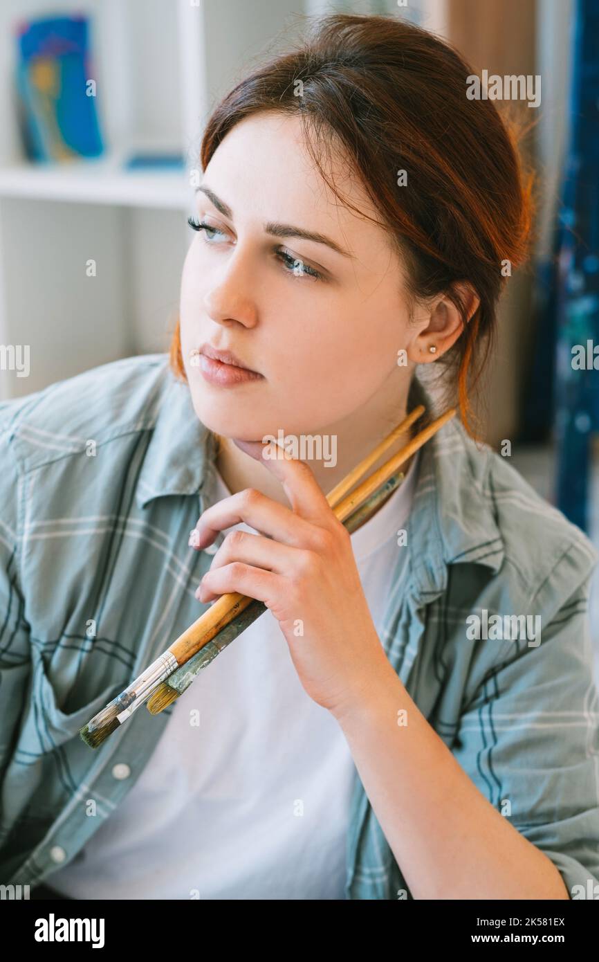 artist portrait inspired woman with paintbrushes Stock Photo