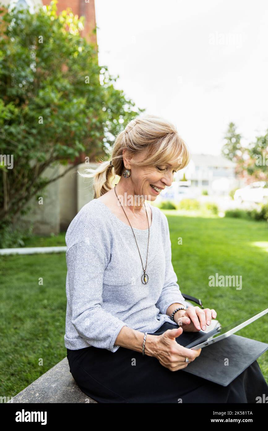 Mature woman sitting on bench hi-res stock photography and images - Alamy