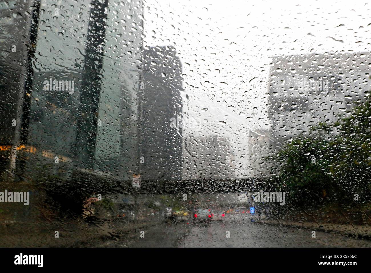 Rain drops on car window. Cold weather rainy season, cloudy wet day
