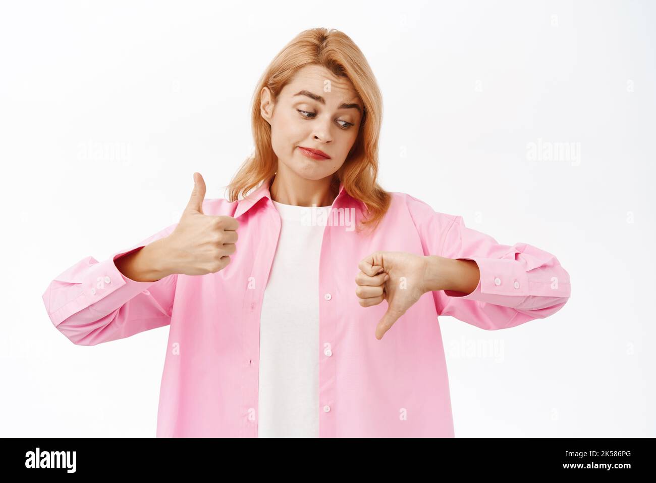 Good or bad. Beautiful redhead woman showing thumbs up thumbs down ...