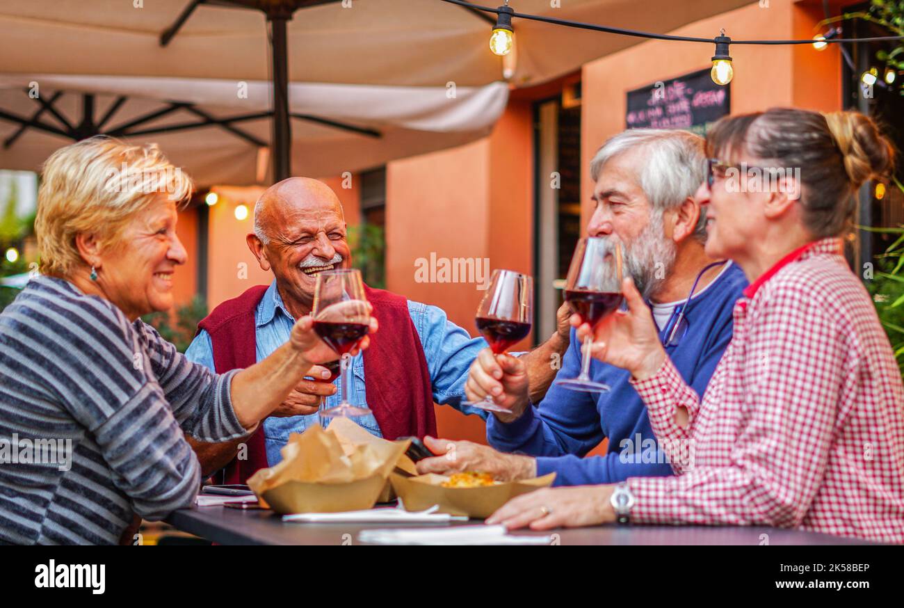 Group of old people eating and drinking outdoor - Senior couples having fun together Stock Photo