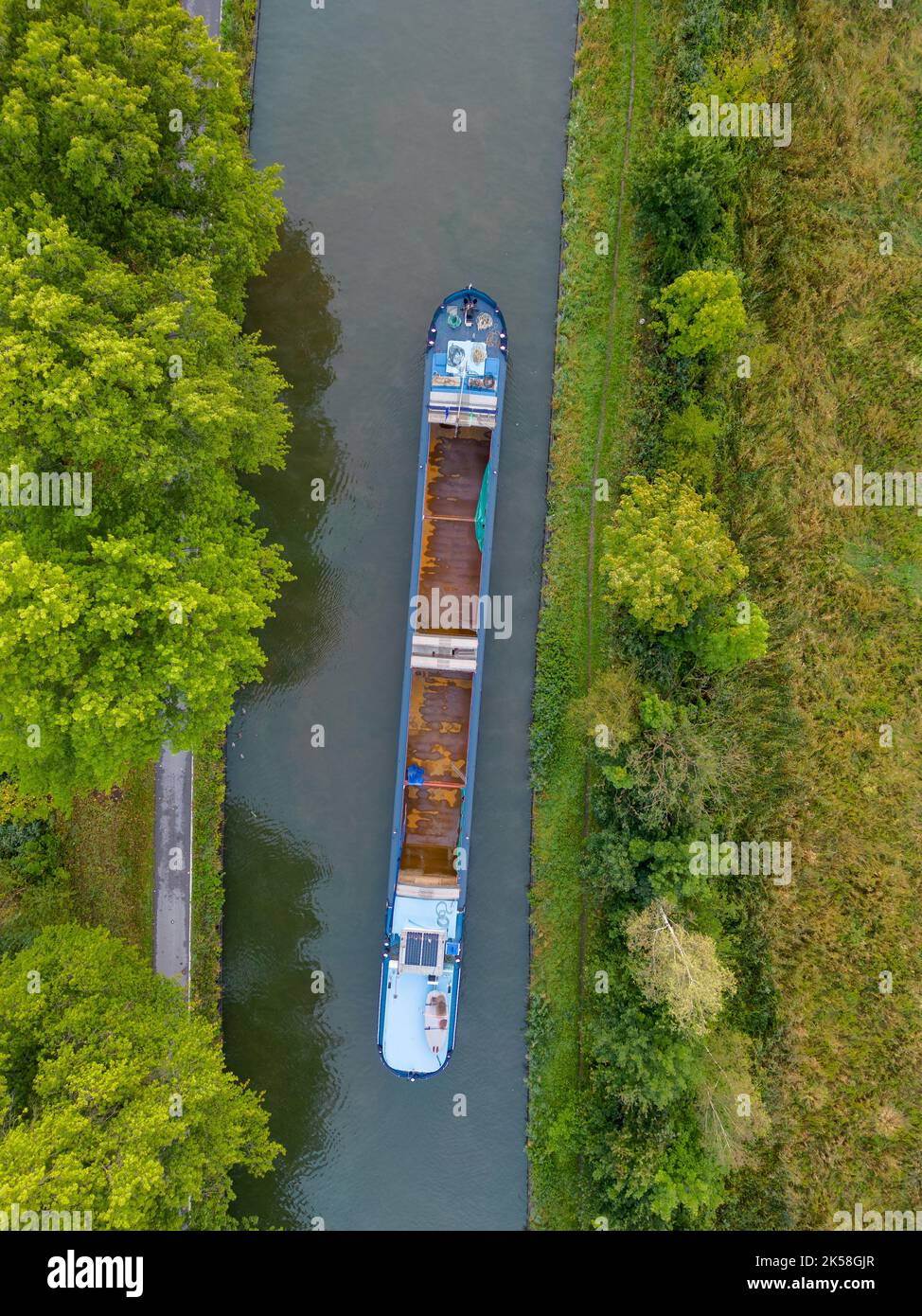 Aerial view of a canal with a cargo boat in Belgium. Canals with water for transport, agriculture. Fields and meadows. Landscape aerial view shot from a drone. High quality photo Stock Photo