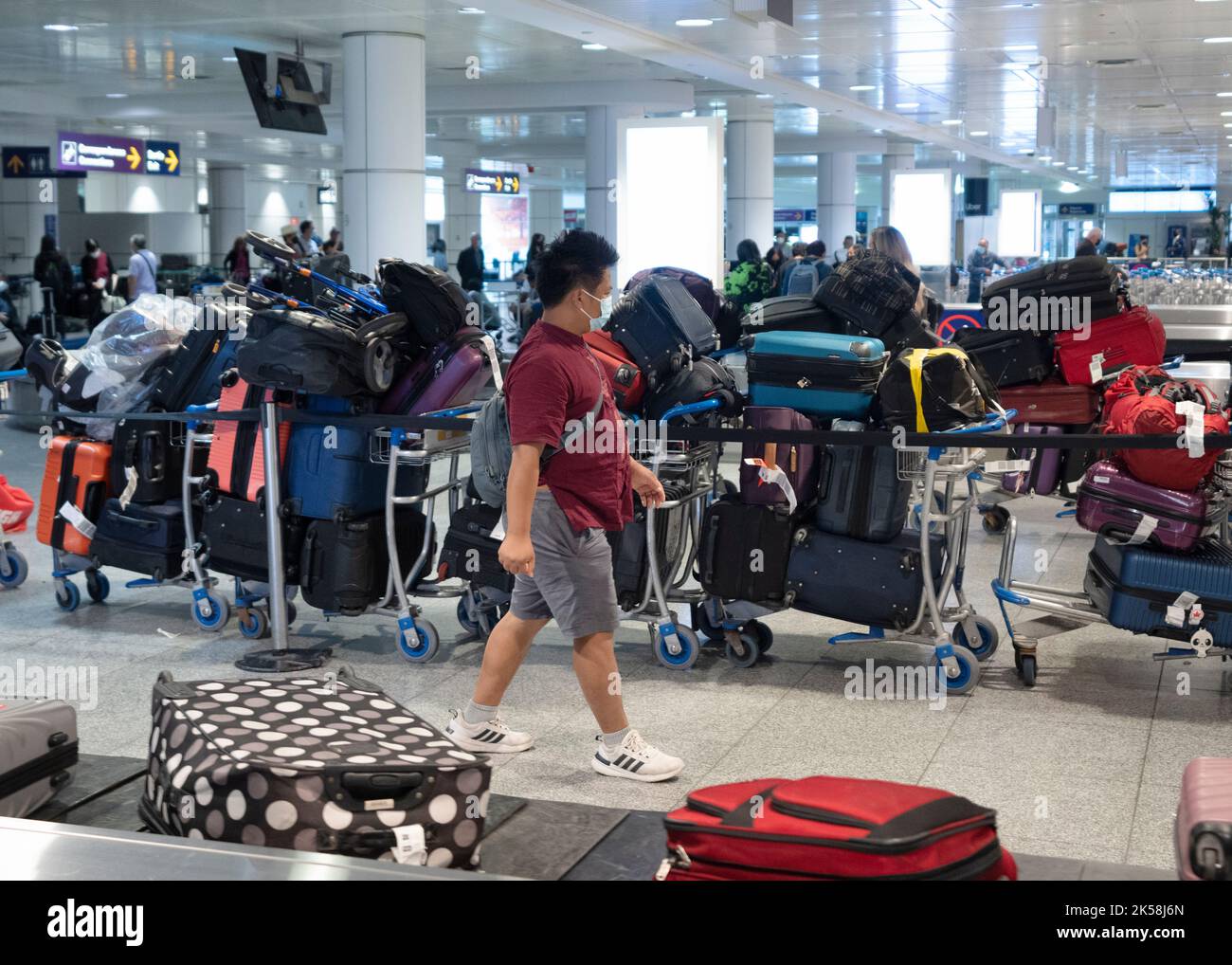 A passenger looks for his luggage among a pile of unclaimed baggage at