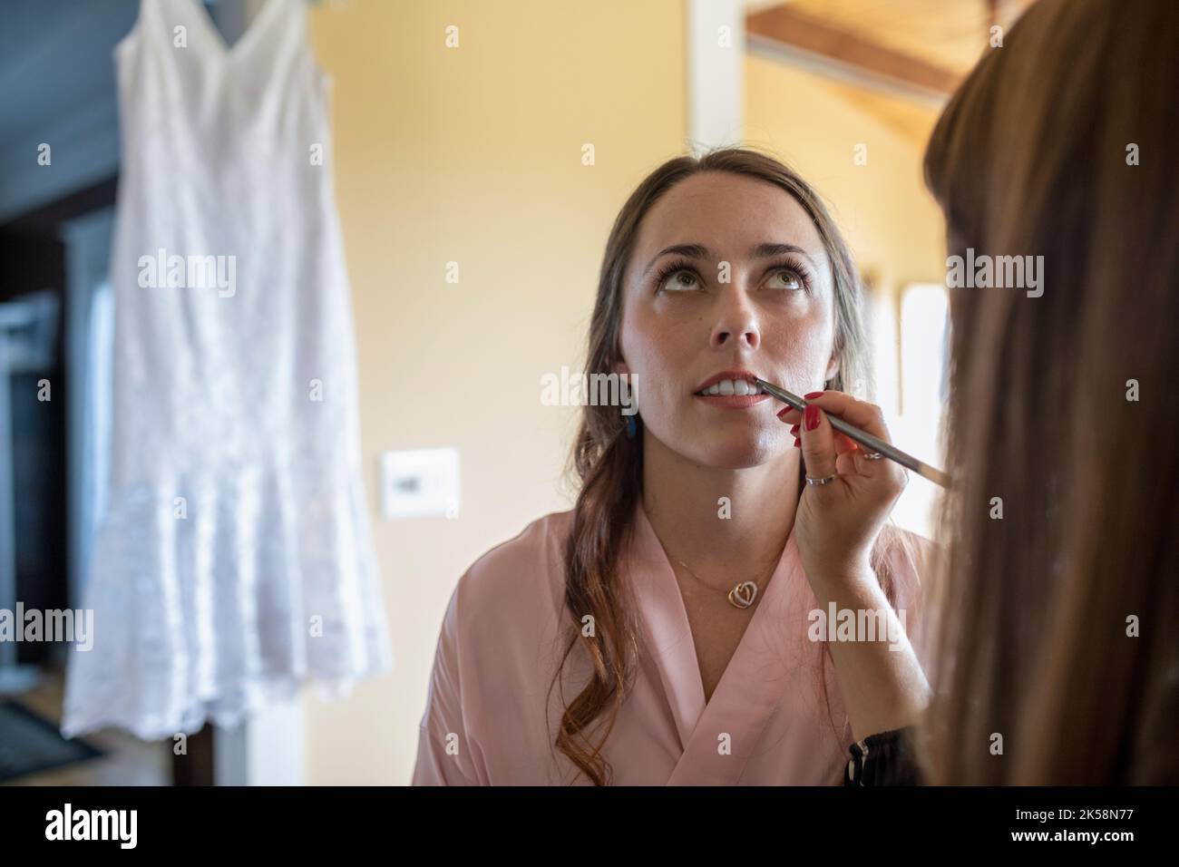 Bride getting makeup done by makeup artist on wedding day Stock Photo ...