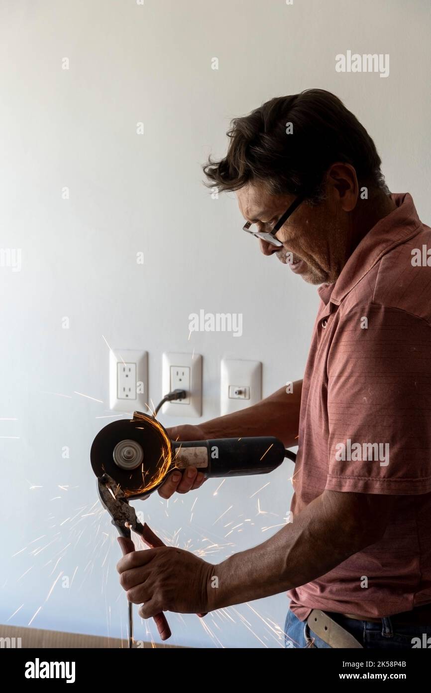 man using angle grinder, cutting a screw, friction sparks, clamping