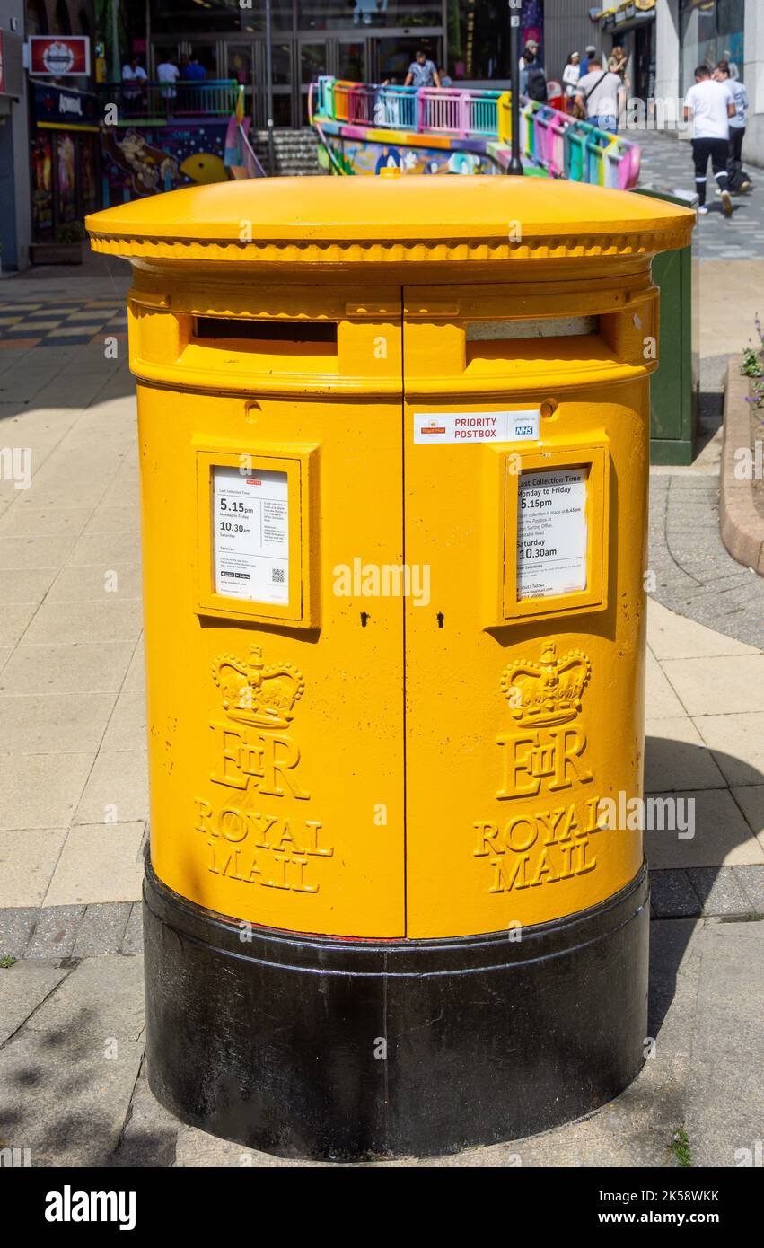 Yellow Royal Mail pillar box (priority postbox), Street, Luton