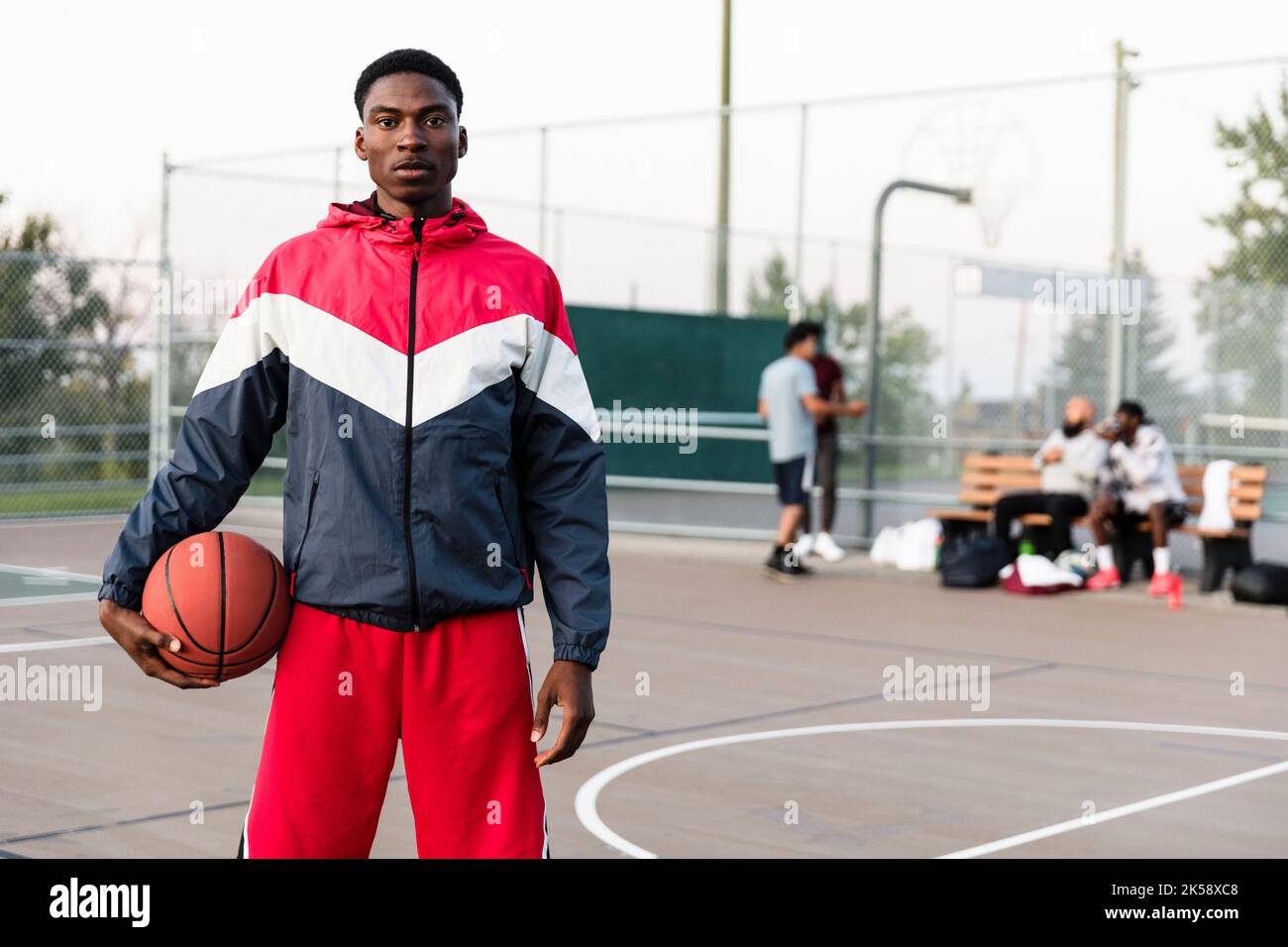 Basketball player holding ball and facing camera Stock Photo