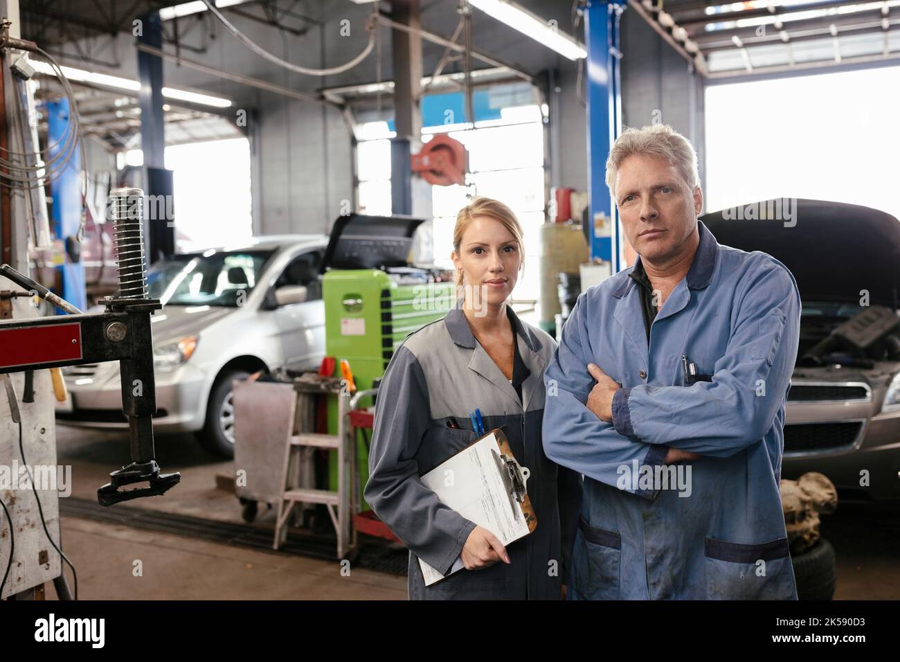 Portrait of two mechanics in garage wearing overalls Stock Photo Alamy