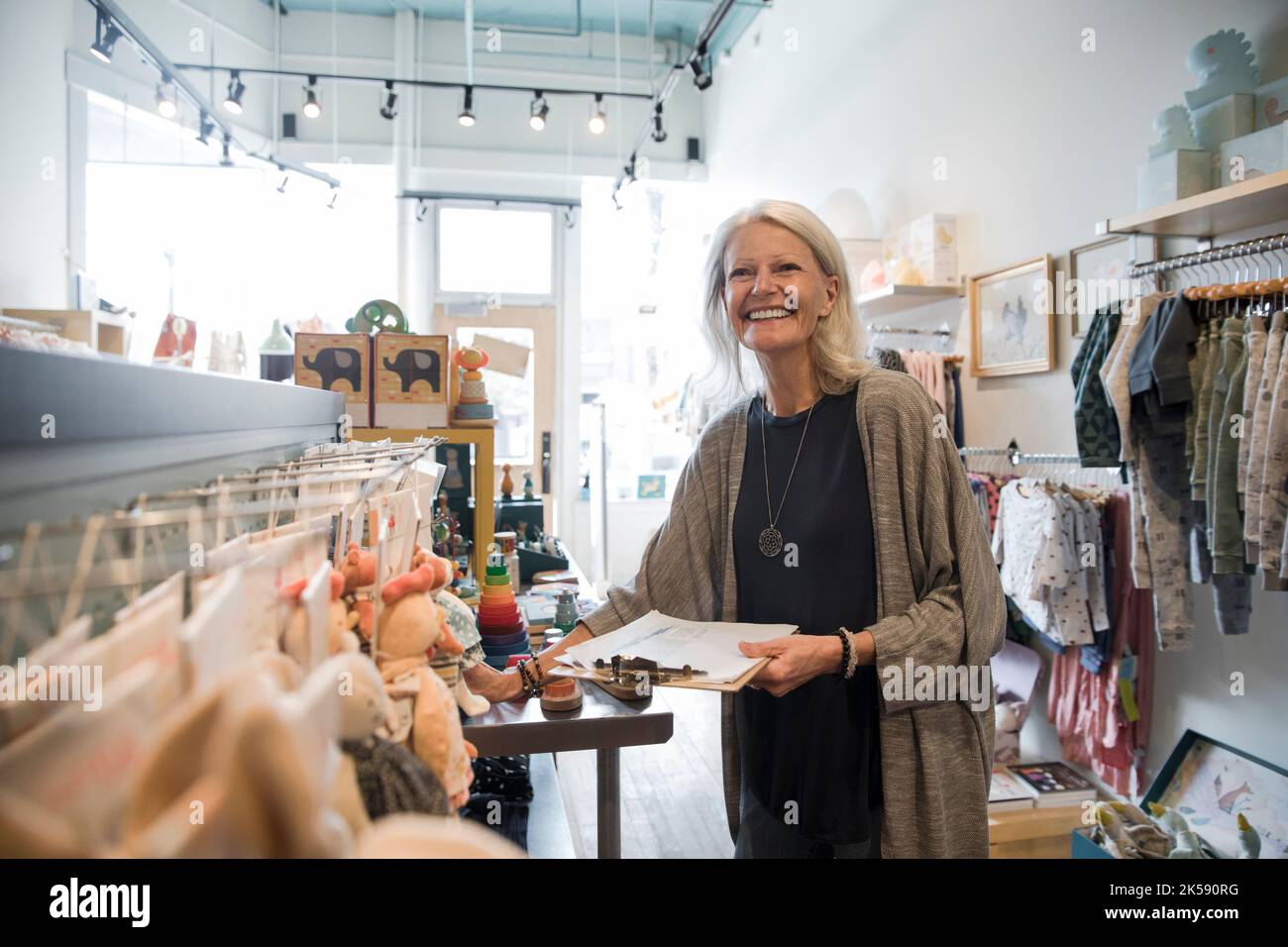 Portrait of children's boutique owner smiling Stock Photo Alamy