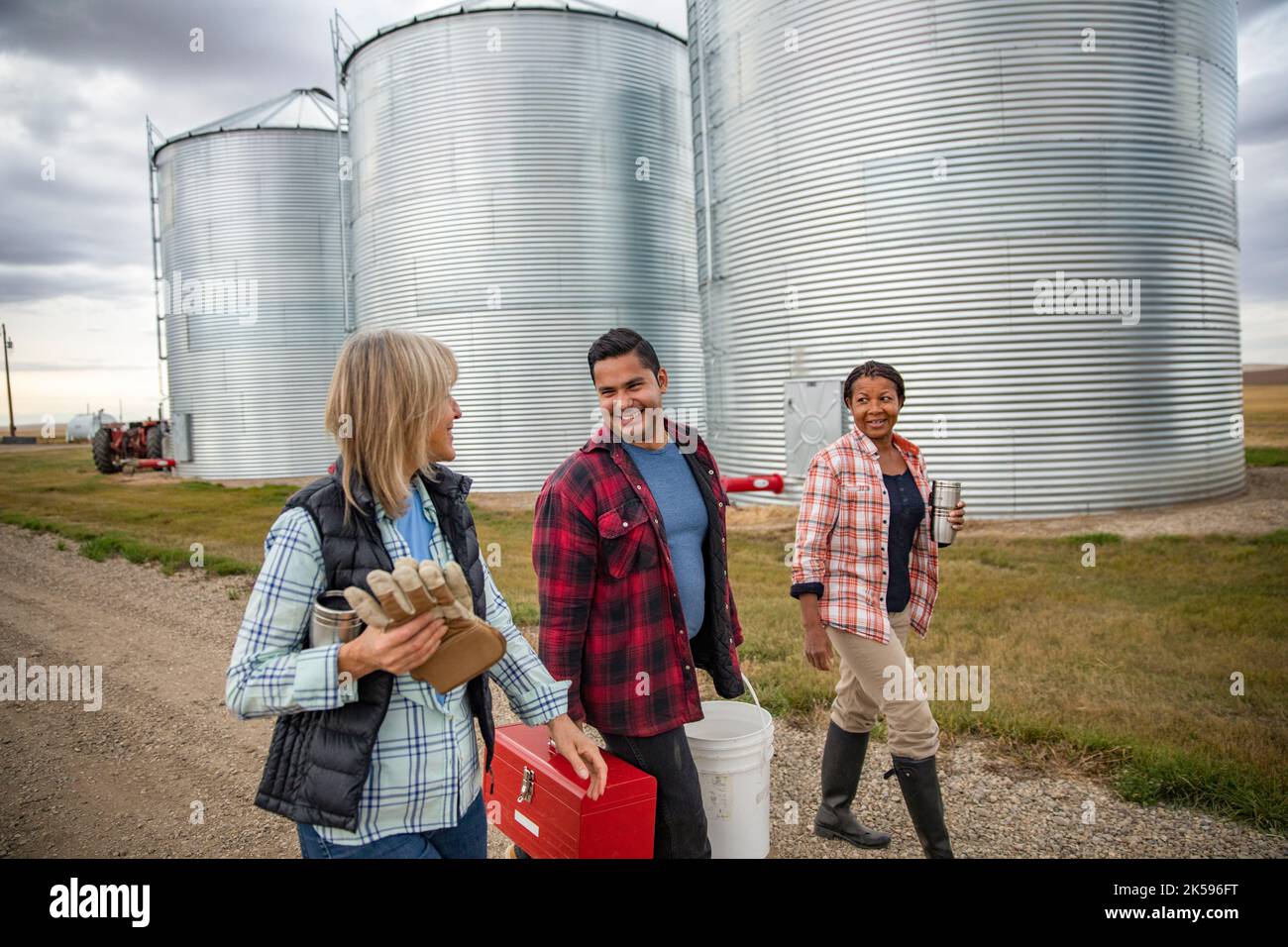 Farmers walking along silos on farm Stock Photo Alamy