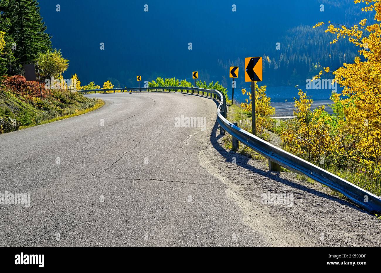 A two lane highway rounding a sharp corner on the Maligne Lake road in Jasper National Park Alberta Canada. Stock Photo