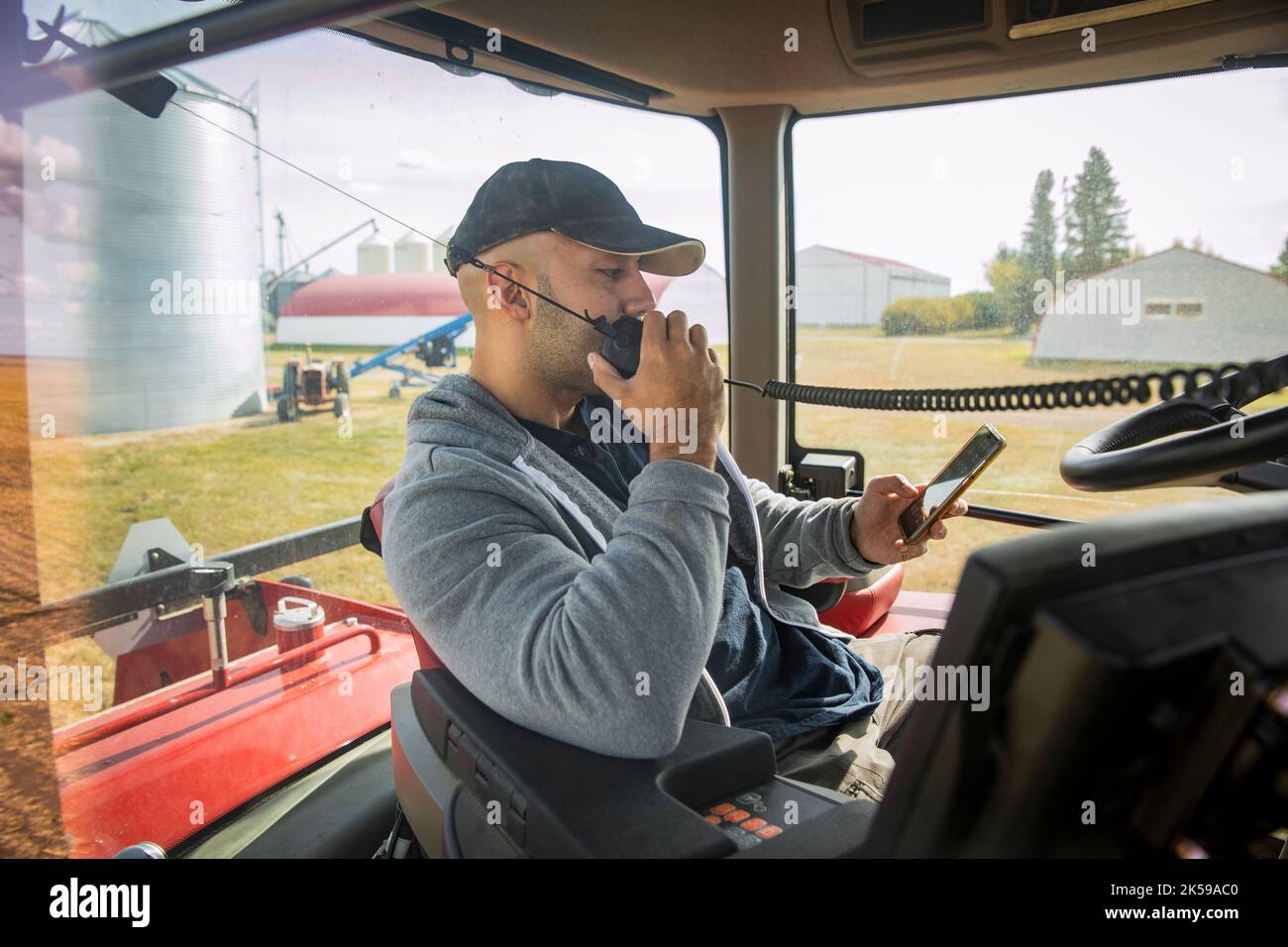 Male farmer using CB radio, driving tractor Stock Photo Alamy