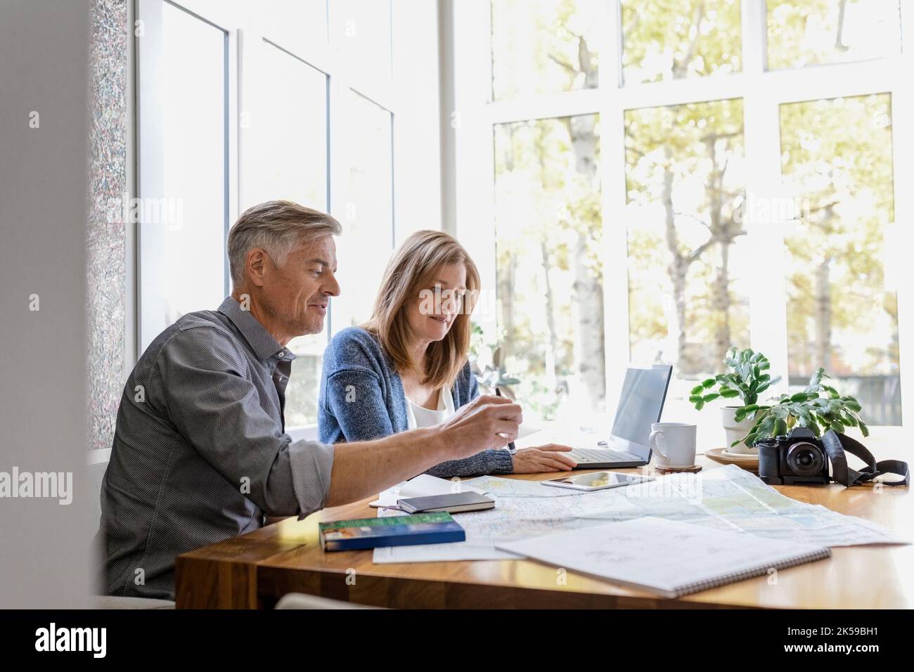 Couple planning holiday with laptop and map Stock Photo Alamy