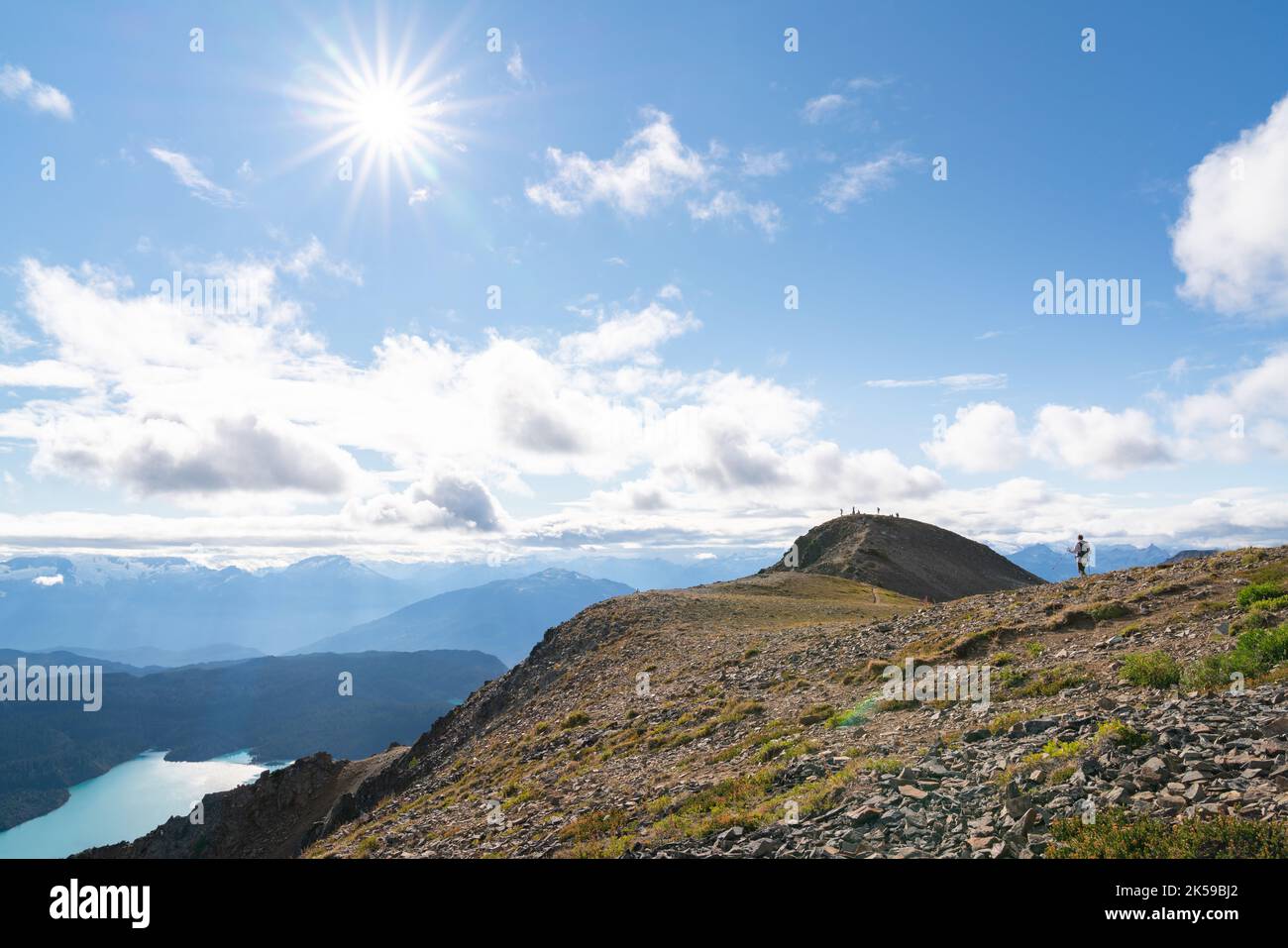 A woman hikes along the Panorama Ridge with Garibaldi Lake far below