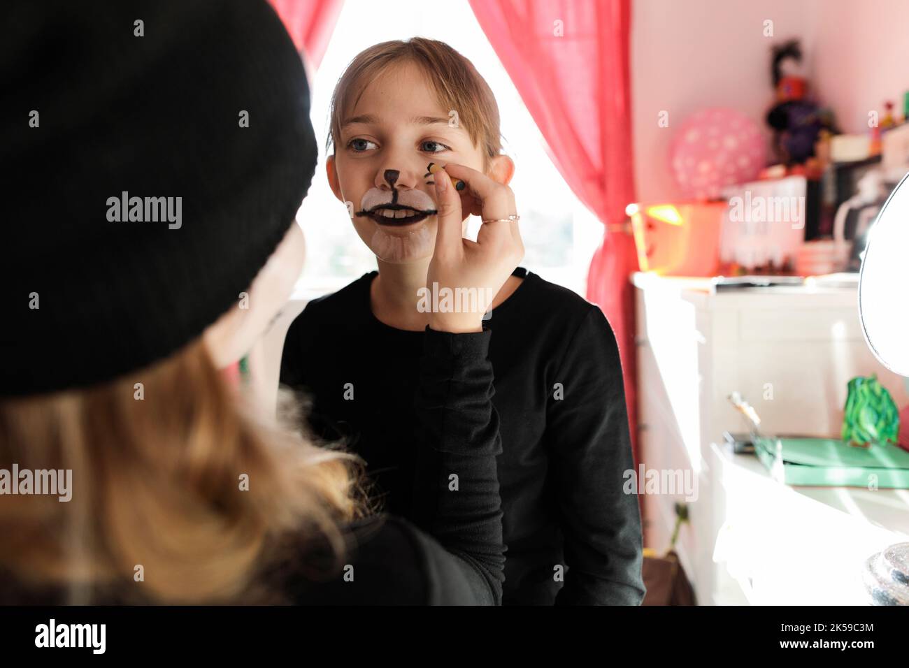 Girl helping sister with Halloween makeup Stock Photo - Alamy