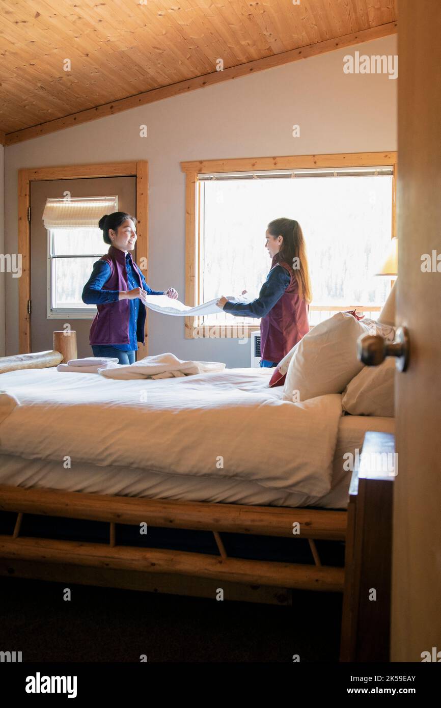 Female hotel employees folding linens in lodge Stock Photo