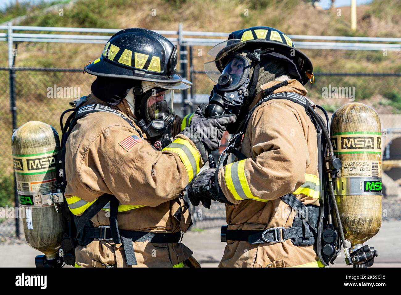 Firefighters John Russum and Tad Fragale with the 914th Fire Emergency Services do a quality check of each other's protective gear before putting out an interior structure fire within a simulated Boeing 737 crash at a training facility in Rochester, New York, August 24, 2022. Ensuring protective equipment is in good shape prior to putting out fires is essential to protect firefighters from potentially fatal flames and gasses. (U.S. Air Force Photo by Airman Kylar Vermeulen) Stock Photo
